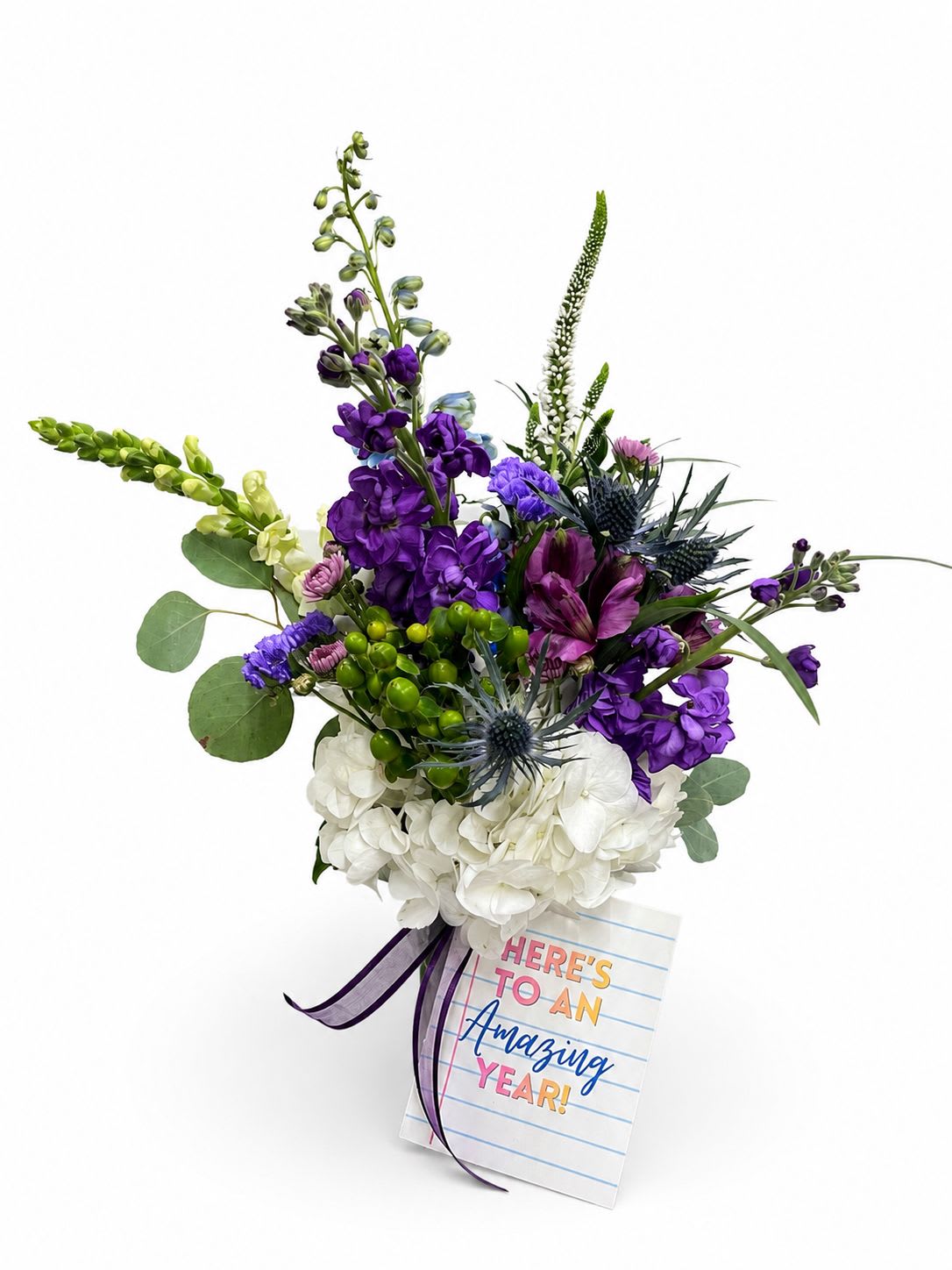 Amazing Year, Purple Cheer - Amazing Year, Purple Cheer is the perfect way to celebrate the start of a new school year. Designed in a classic mason jar and finished with a notebook-inspired tag that reads, "Here's to an Amazing Year!", this cheerful arrangement makes a thoughtful gift for teachers, school staff, administrators, or anyone beginning a new chapter.  This beautiful bouquet features a fresh mix of purple and white blooms, including Veronica, Snapdragon, Hydrangea, Stock, Hypericum berries, Thistle, and Chrysanthemums. The combination of soft textures and vibrant colors creates a charming, garden-inspired design that's perfect for brightening classrooms, offices, or homes.  Whether you're welcoming a favorite teacher back to school, thanking an educator for their dedication, or celebrating a student's fresh start, Amazing Year, Purple Cheer is a meaningful gift that brings encouragement and smiles. Each arrangement is handcrafted with the freshest seasonal flowers, and substitutions may be made when necessary to maintain the overall style, color palette, and value.  We proudly offer local flower delivery in Smyrna, Mableton, Marietta, Austell, and Powder Springs, Georgia, making it easy to send a beautiful back-to-school surprise to someone special.