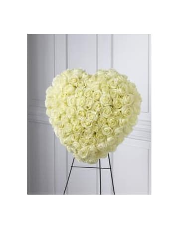 Heart-shaped arrangement of white roses on a stand