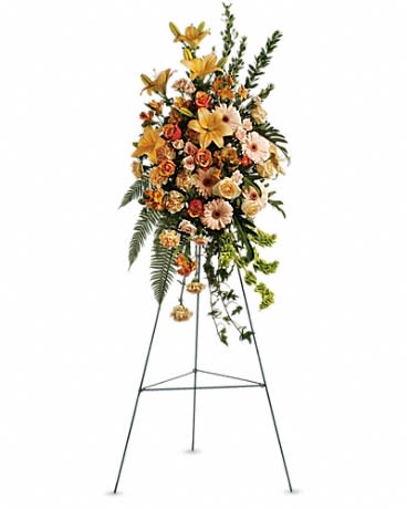 Tall floral standing spray on an easel with orange and peach blooms