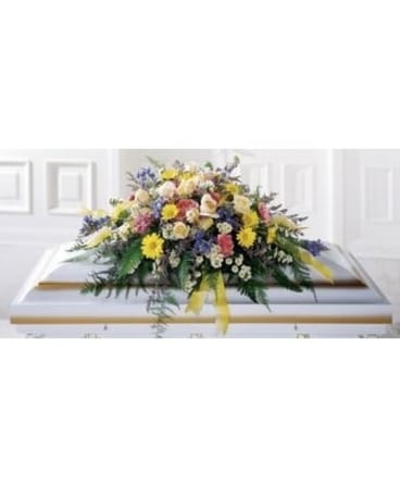 Colorful floral casket spray with yellow, white, pink, and blue flowers