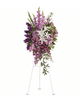 Standing floral spray with pink and purple flowers on a white easel