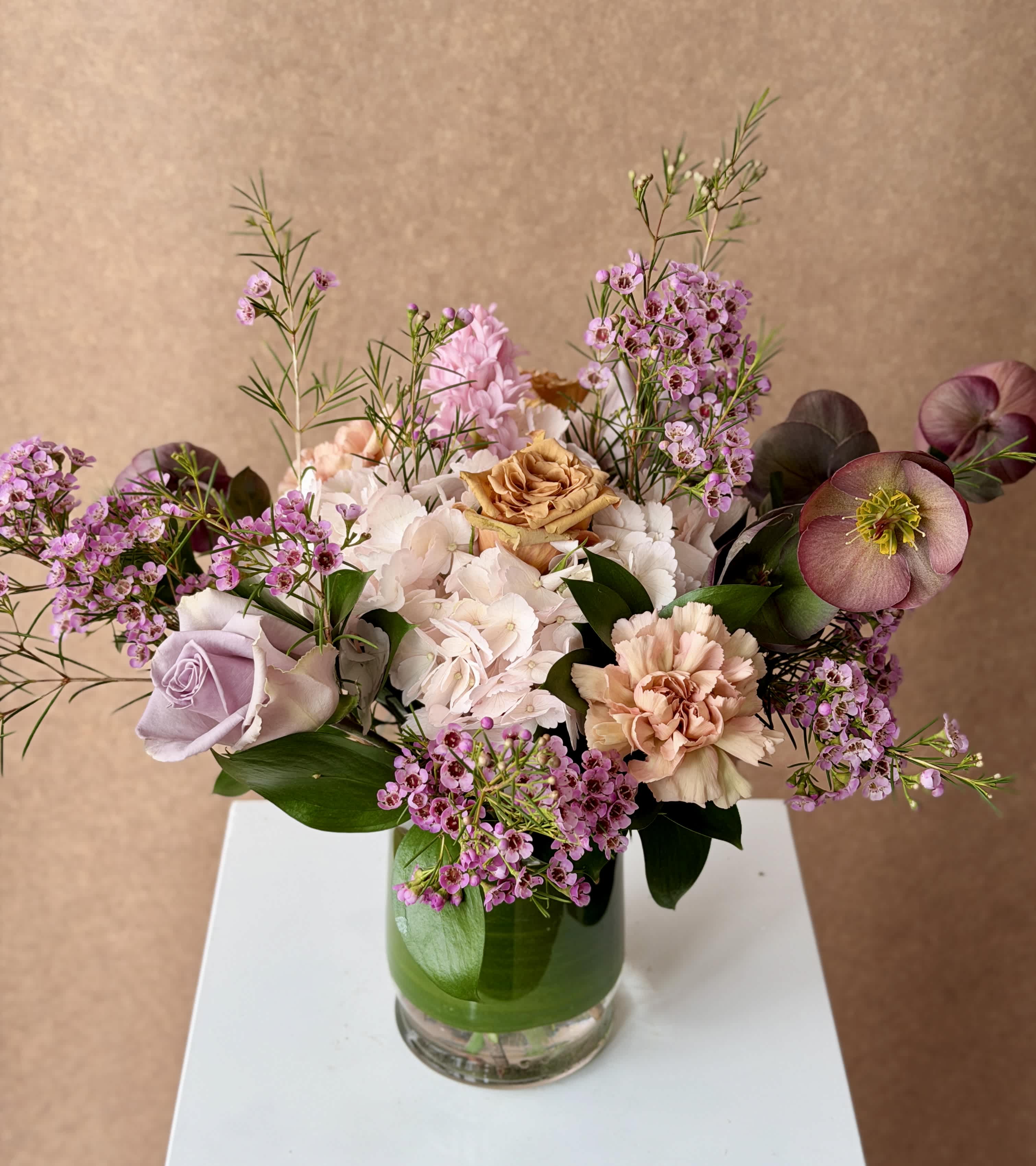 Mixed bouquet of pink and cream flowers in a glass vase
