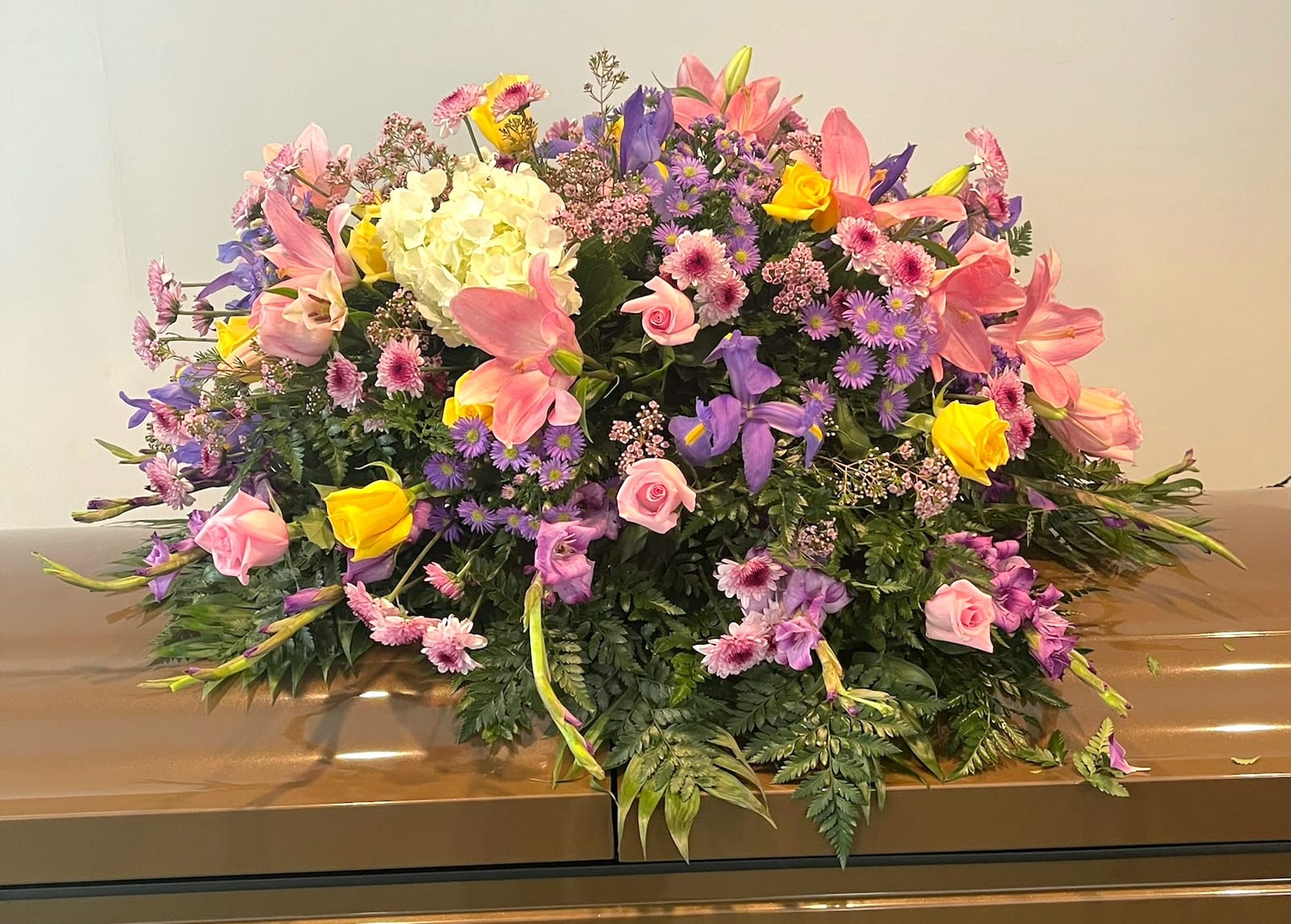 Large pink, purple, and yellow floral spray on a casket