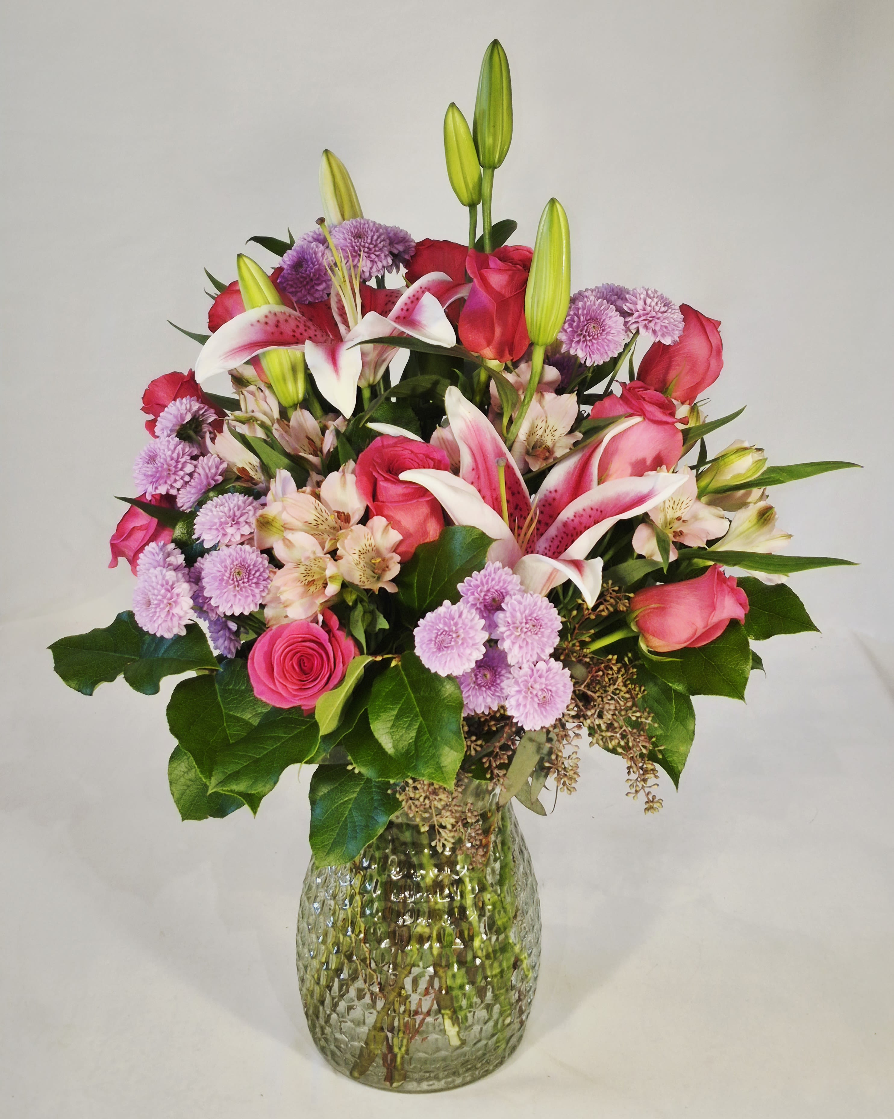 Pink Perfection  - Beautiful and fragrant bouquet of stargazer lilies, hot pink roses, pink alstromeria, lavender buttons and lush greenery. This stunning bouquet is 22" tall and 16" wide. One of our shop favorites for any occasion. 