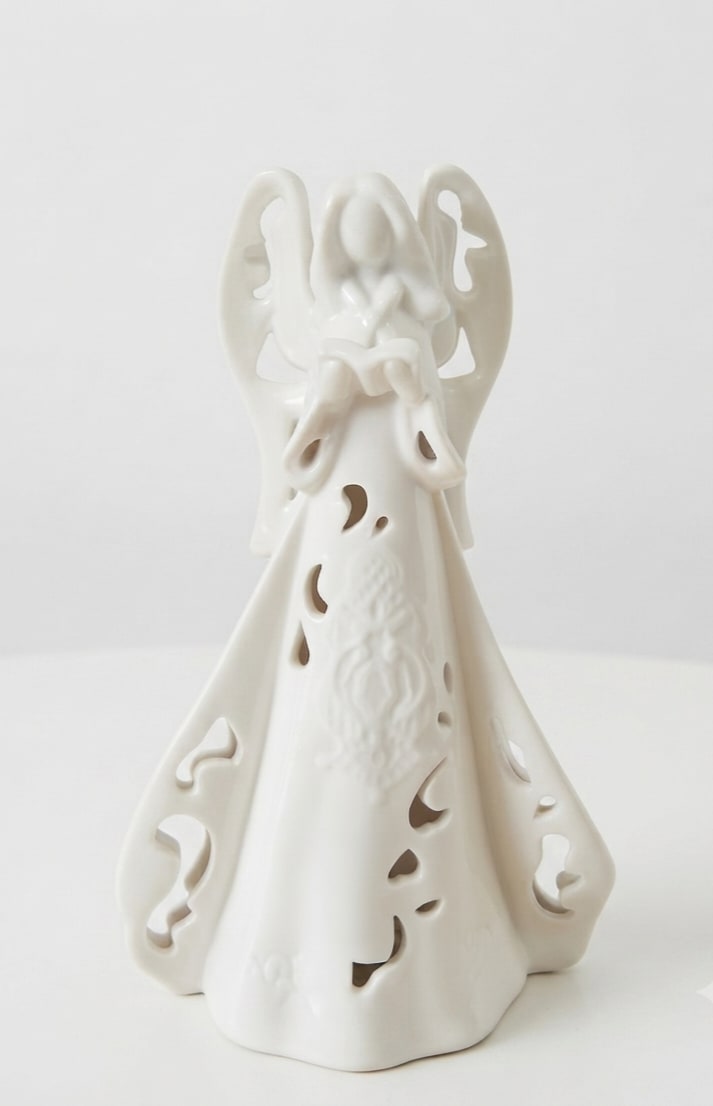 White ceramic angel figurine with cutout details