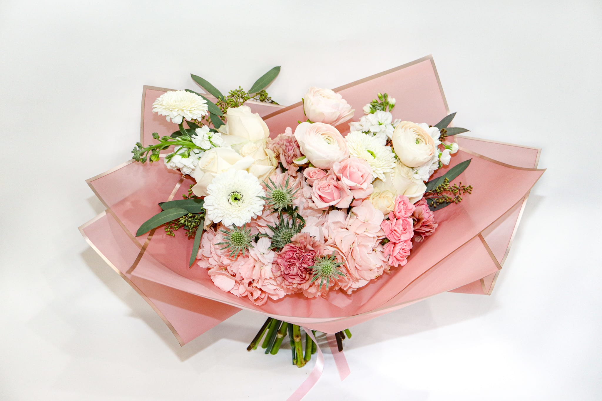 Pink and white mixed bouquet wrapped in translucent pink paper