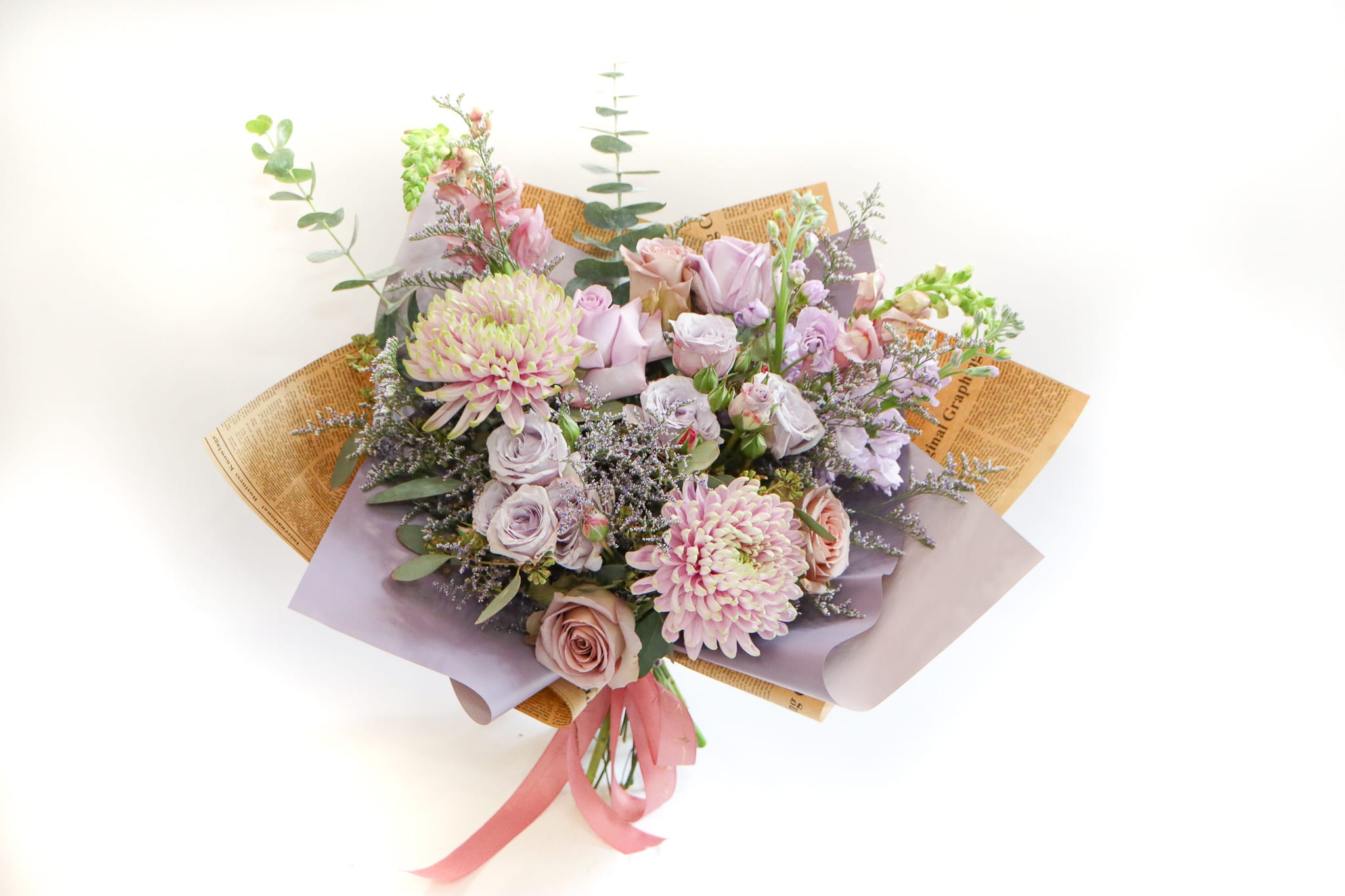 Bouquet of pastel roses and chrysanthemums wrapped in lavender paper