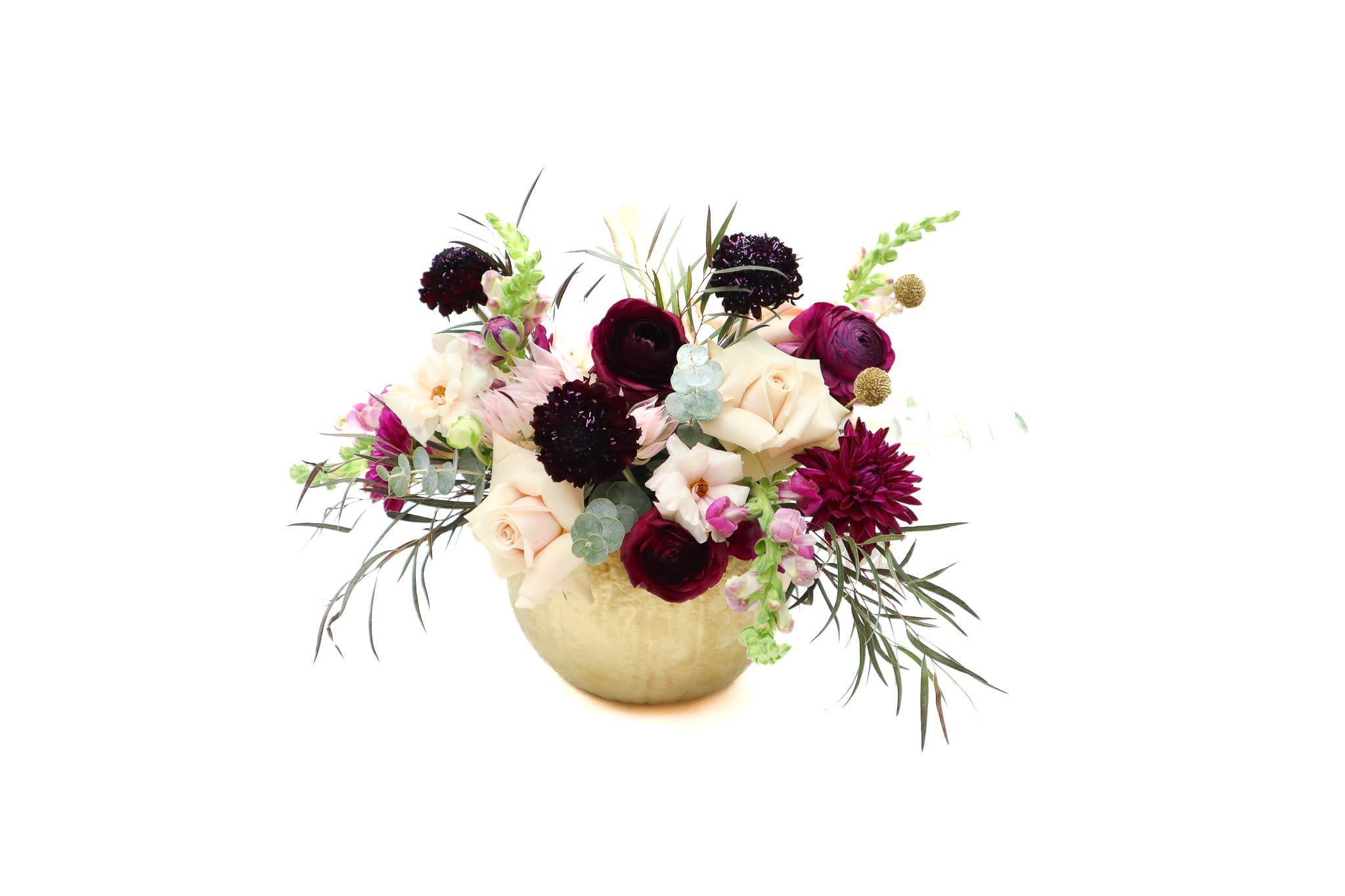 Mixed bouquet of cream, burgundy, and pink flowers in a gold vase