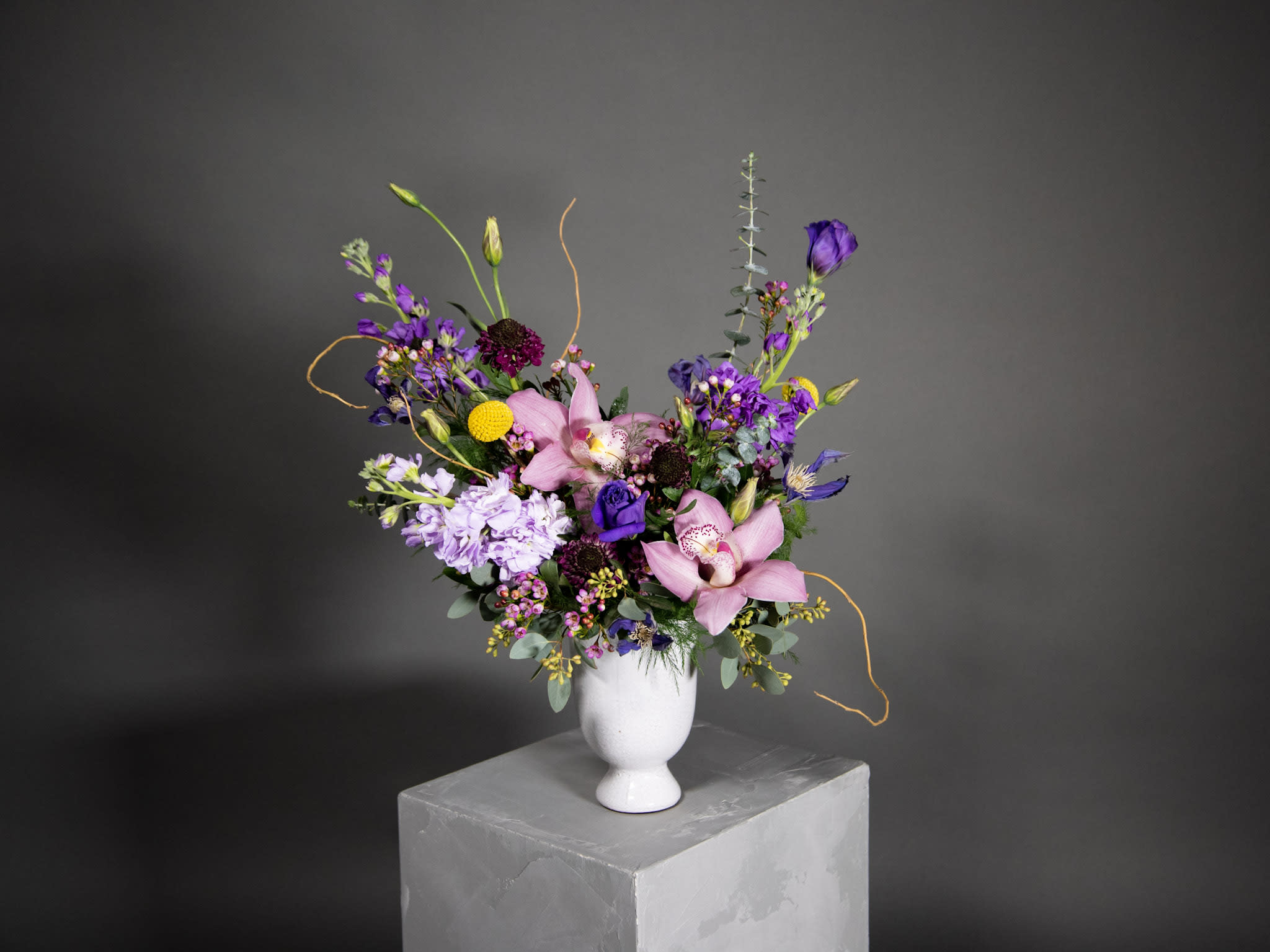 Mixed bouquet of pink and purple flowers in a white vase