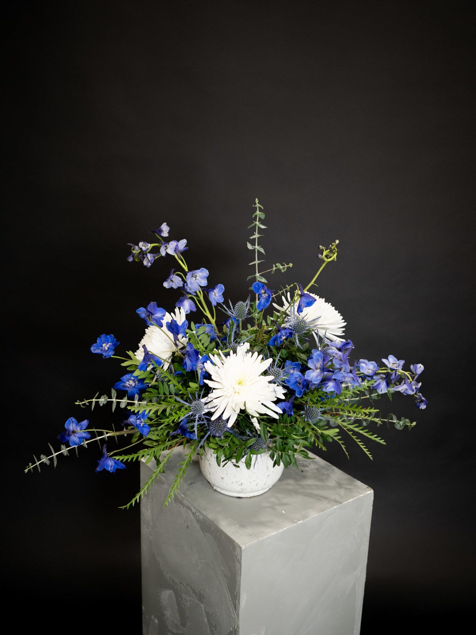 Blue and white flower arrangement in a white vase