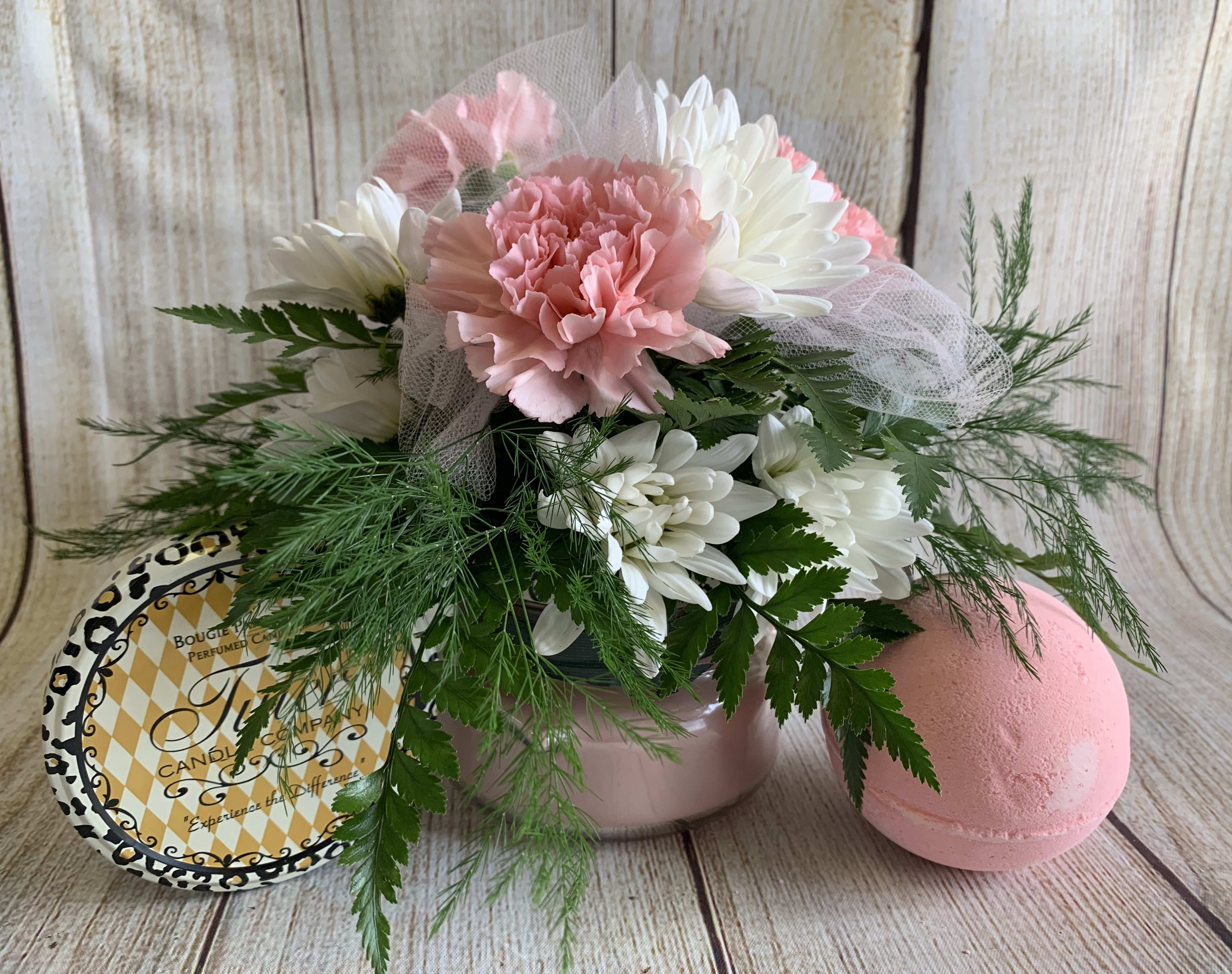 Pink and white flower arrangement with a candle tin and pink bath bomb
