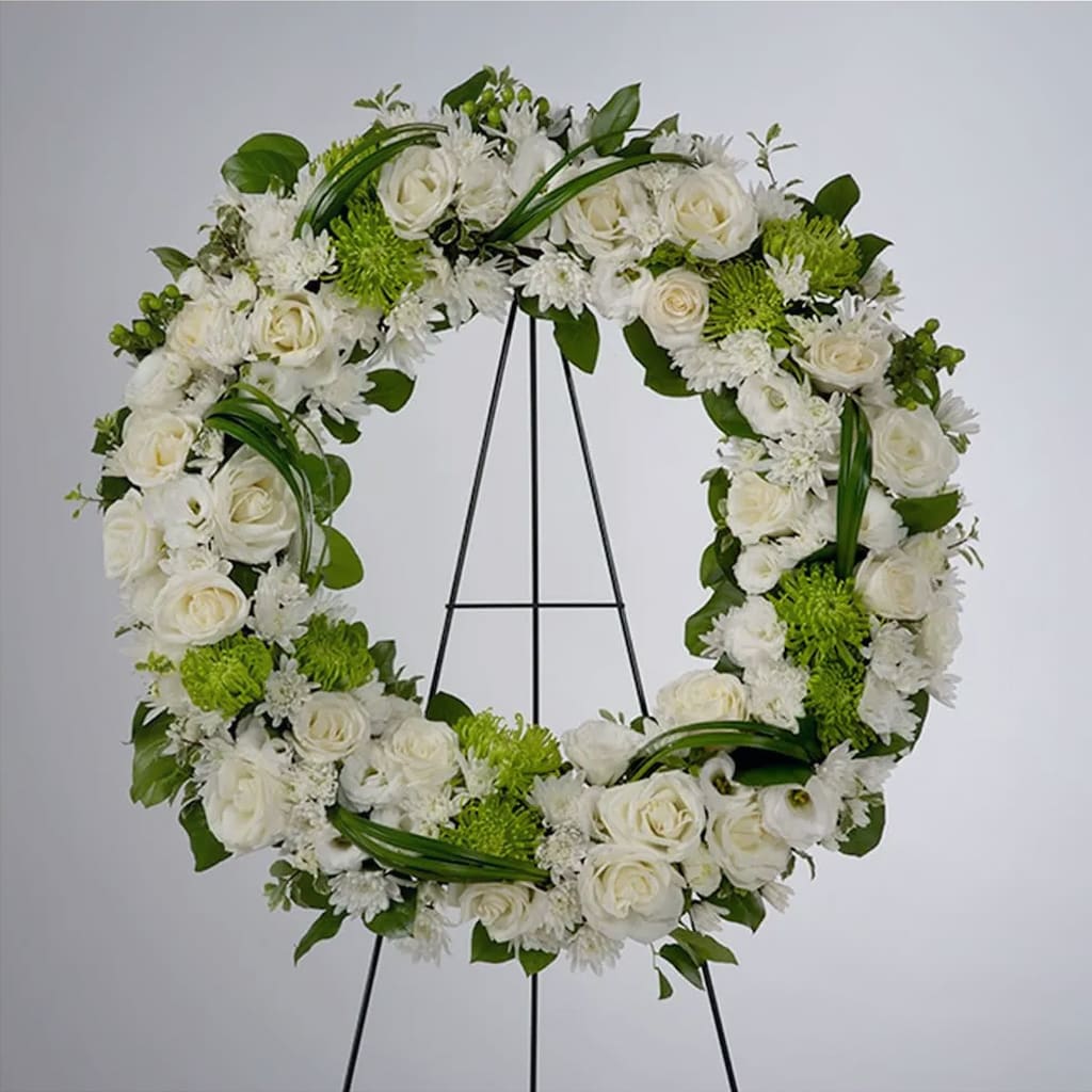 Lasting Serenity Easel Wreath - A beautiful white and green tribute wreath that calms, this easel wreath arrangement celebrates a full life and a peaceful passing.  Flowers Including roses, chrysanthemums, carnations, green spider mums, alstroemeria, assorted lush greenery and decorative foliage.  Approximately 24" in diameter.