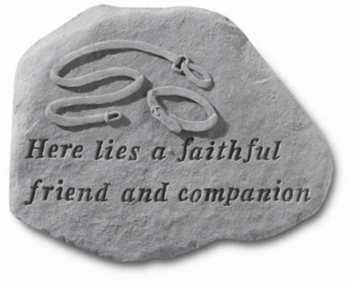 Gray memorial stone with engraved text and a carved dog collar