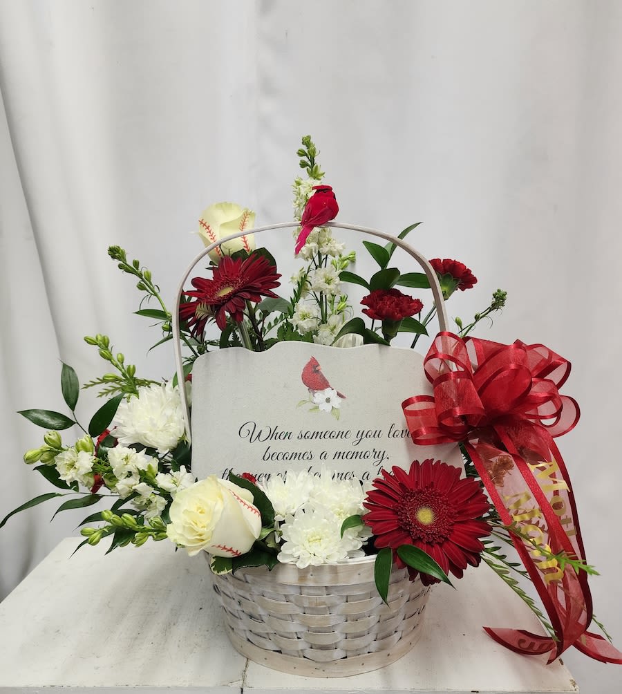 Basket arrangement with red and white flowers and a memorial card