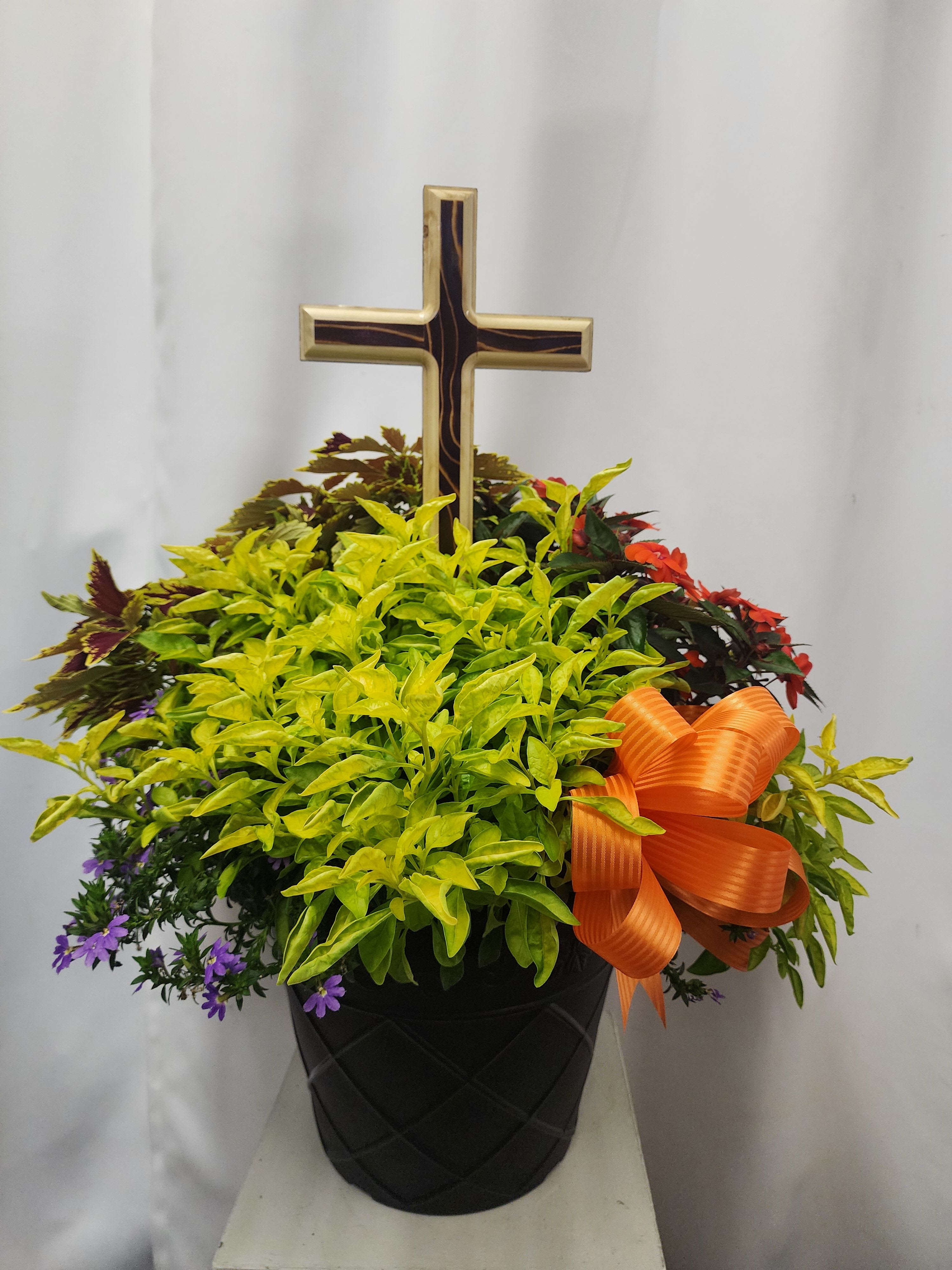 13” Seasonal Annual Planter – A Unique and Heartfelt Gift with 15in. Keepsake Wooden Cross - Brighten any space with our 13-inch planter, arranged with a vibrant assorted seasonal annuals. Each planter is individually planted on-site by our expert team, ensuring a one-of-a-kind expression of color, texture, and flourishing life. No two planters are ever exactly alike.   This planter is especially suitable as a sympathy arrangement. Designed to flourish in full sunlight, the planter is both practical and resilient, ideal for patios, porches, or sunny garden corners.    Whether you’re expressing heartfelt condolences, celebrating a green thumb, or simply bringing a breath of fresh beauty to someone’s day, our 13” seasonal annual planter is a thoughtful and enduring choice; each one unique, and planted with care. Comes with a coordinating bow. This planter comes with a 15in hand made keepsake Wooden cross.  