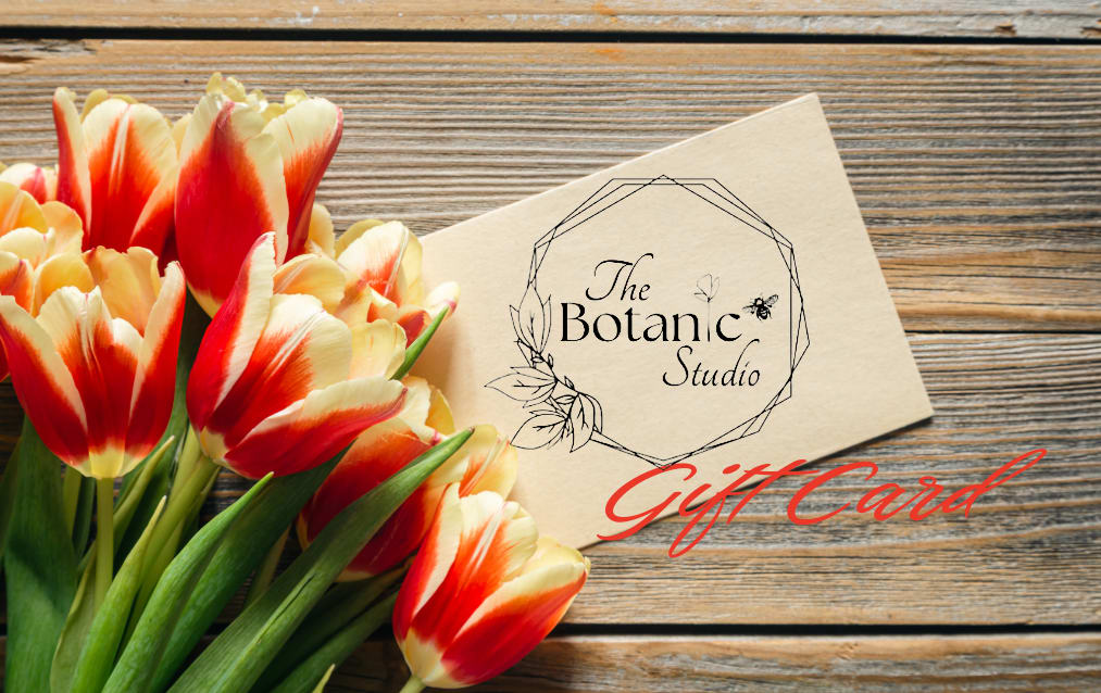 Tulips beside a floral gift card on a wood surface