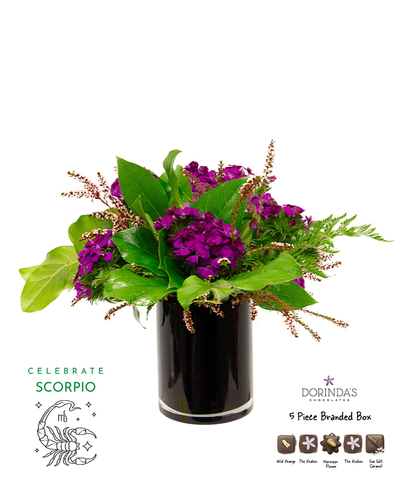 Purple floral arrangement in a black vase with a chocolate box and Scorpio graphic
