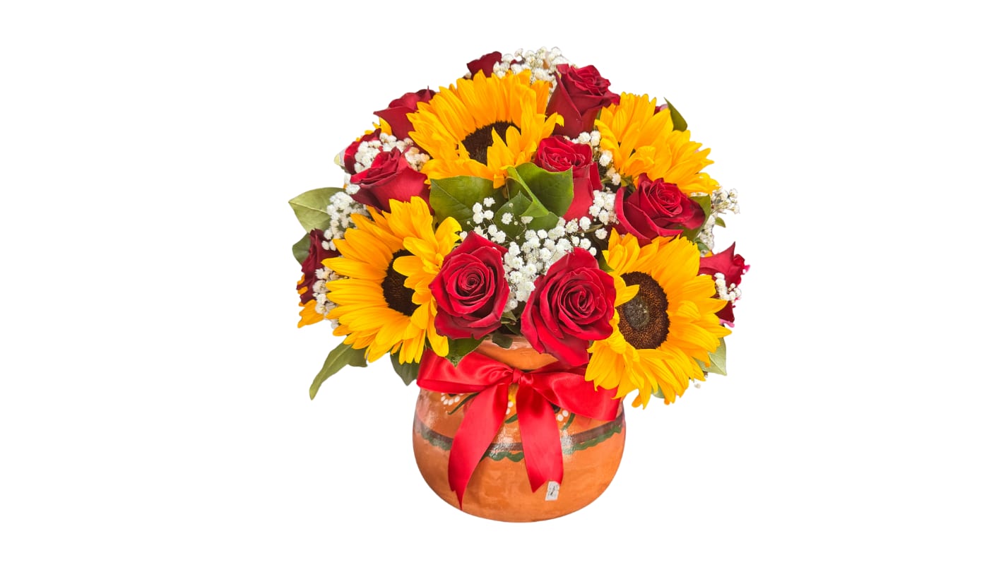 Sunflowers and red roses arranged in a round vase with a red ribbon