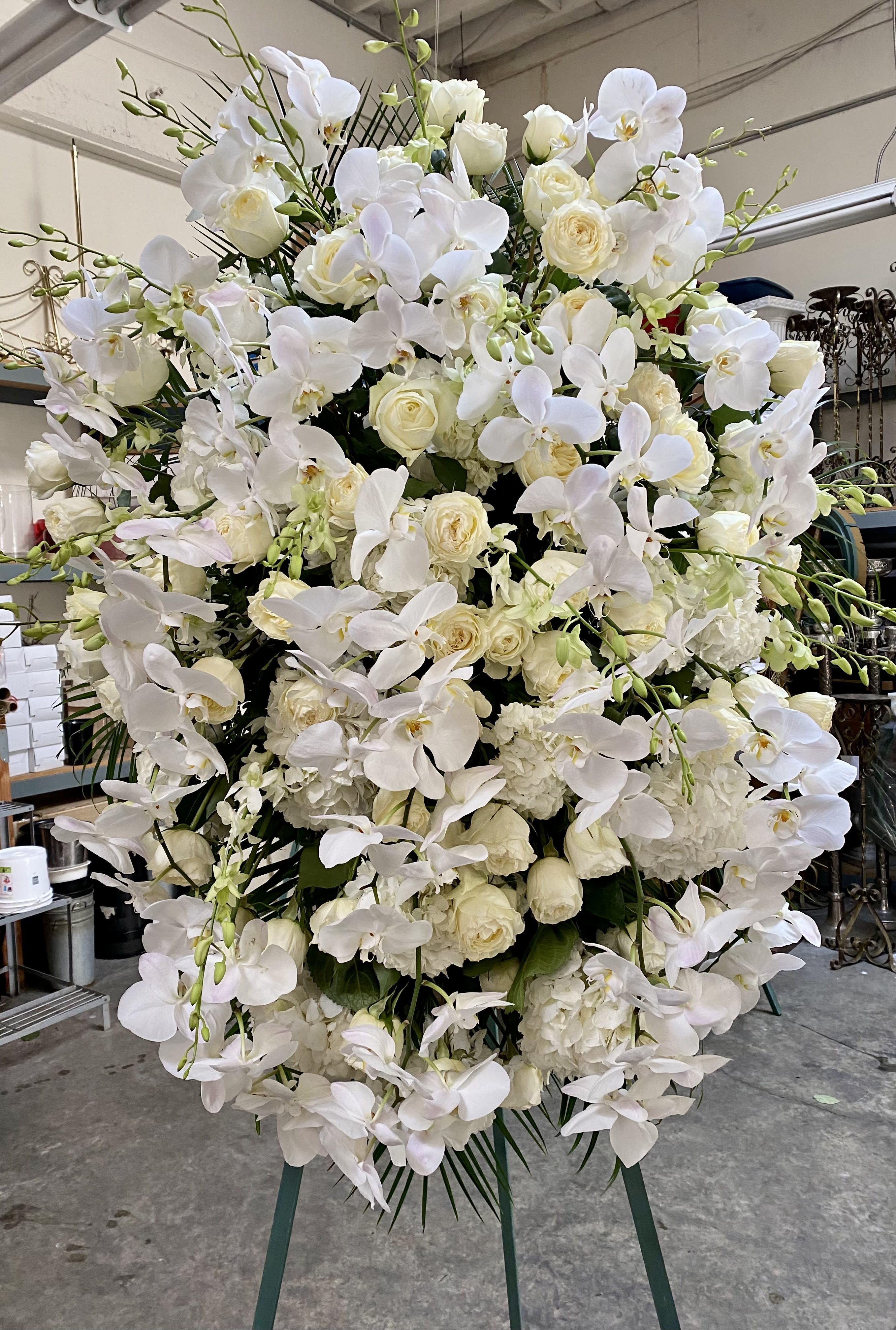 Large white floral standing arrangement with orchids and roses