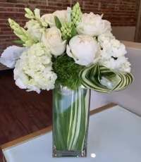 White floral arrangement in a tall glass vase