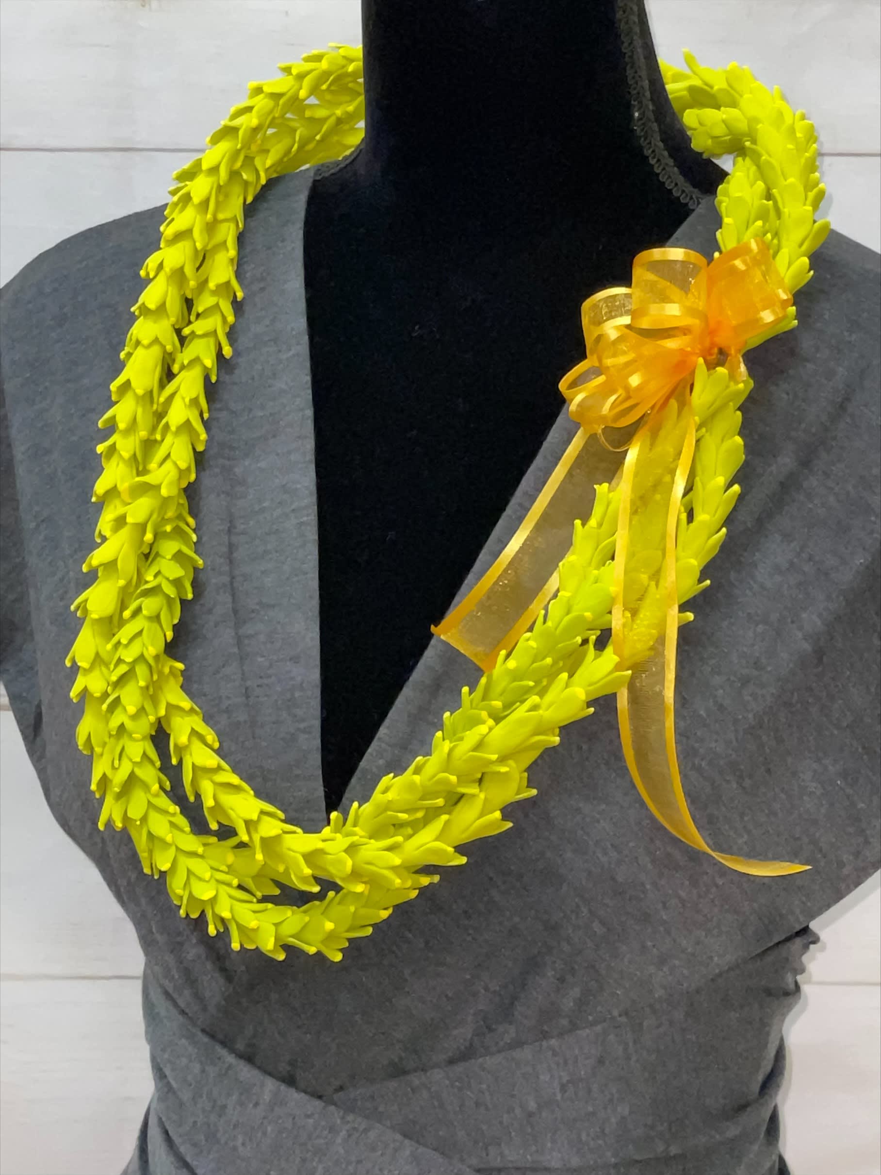 Artificial Clay Pakalana Lei (3 Strands)  - Our locally created clay leis are works of art, meticulously crafted to resemble the beauty of real flowers. Although artificial, these leis do not have the fragrance of natural flowers, they offer a lasting and stunning alternative. Key features include:  Handcrafted Artistry: Made with actual clay, each lei is carefully crafted to look just like the original flower, showcasing exquisite detail and craftsmanship. Durable and Long-Lasting: As an artificial lei, it will not wilt or deteriorate, ensuring longevity and durability. Fragrance-Free: While these leis do not have the natural fragrance of real flowers, their beauty and realism more than make up for it. Perfect for Any Occasion: Ideal for weddings, graduations, special events, or as a decorative piece that brings a touch of Hawaiian charm to any setting. Locally Created: Proudly made by local artisans, supporting the local community and preserving traditional craftsmanship. Celebrate with the timeless beauty of our clay leis, perfect for any occasion and a lasting reminder of Hawaii's floral splendor.