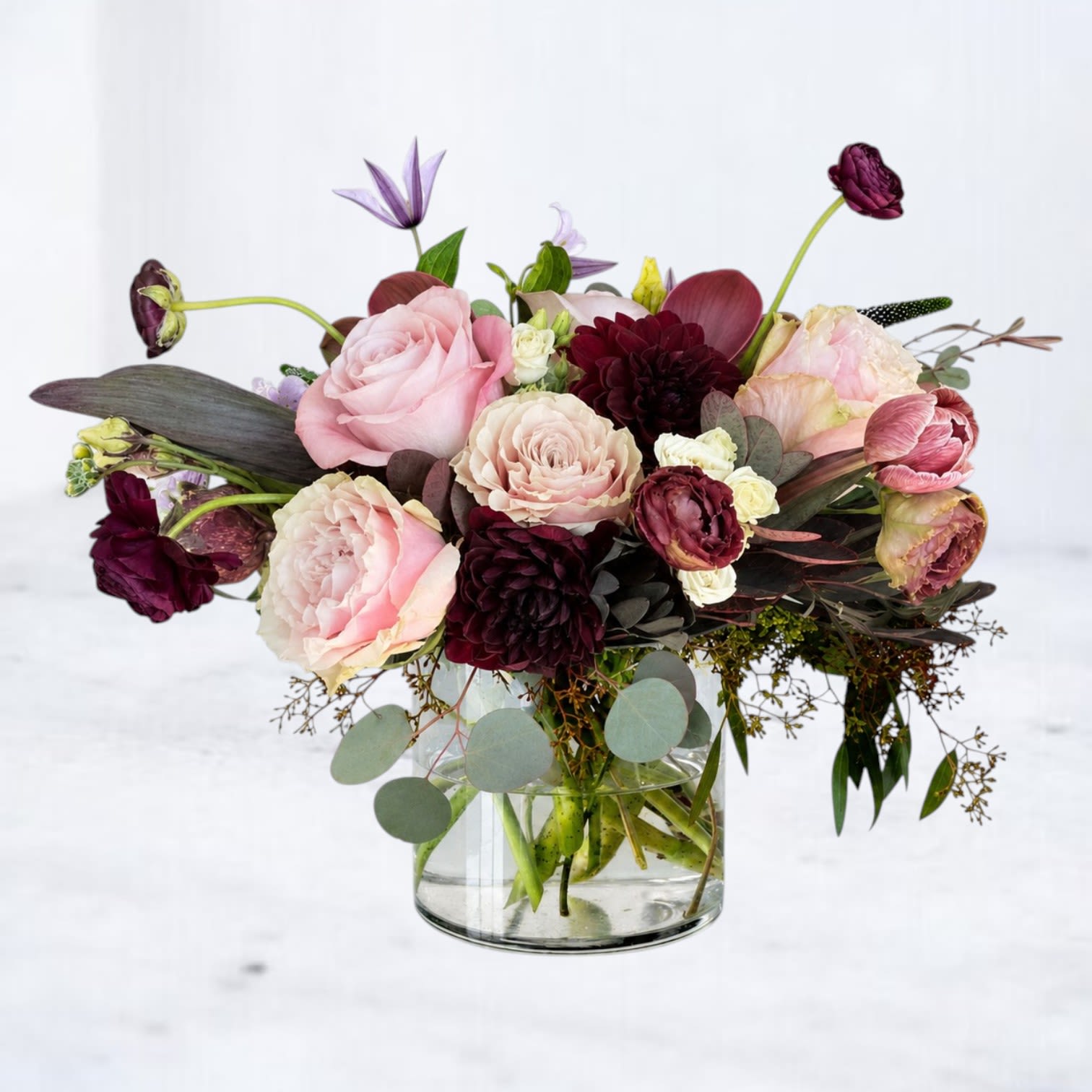 Ashbury - Ashbury is a sophisticated designer flower arrangement featuring blush garden-style roses, burgundy dahlias, ranunculus, lisianthus, calla lilies, and premium seasonal flowers accented with lush greenery and textural foliage. Designed in a clear glass vase, this luxurious bouquet blends soft blush tones with deep wine hues for an elegant, editorial look that's perfect for birthdays, anniversaries, romance, thank you gifts, housewarmings, or simply elevating any space. Every Whiskey Wallflower arrangement is handcrafted using the freshest seasonal flowers, making each design beautifully unique while maintaining the same rich color palette and upscale aesthetic. Hand-delivered throughout Magnolia, Montgomery, The Woodlands, Conroe, Spring, Tomball, Cypress, and surrounding North Houston communities.