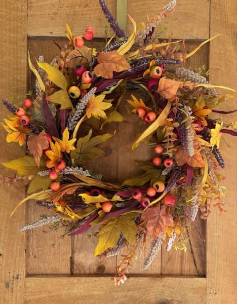 Autumn wreath with berries and mixed foliage on a wooden door