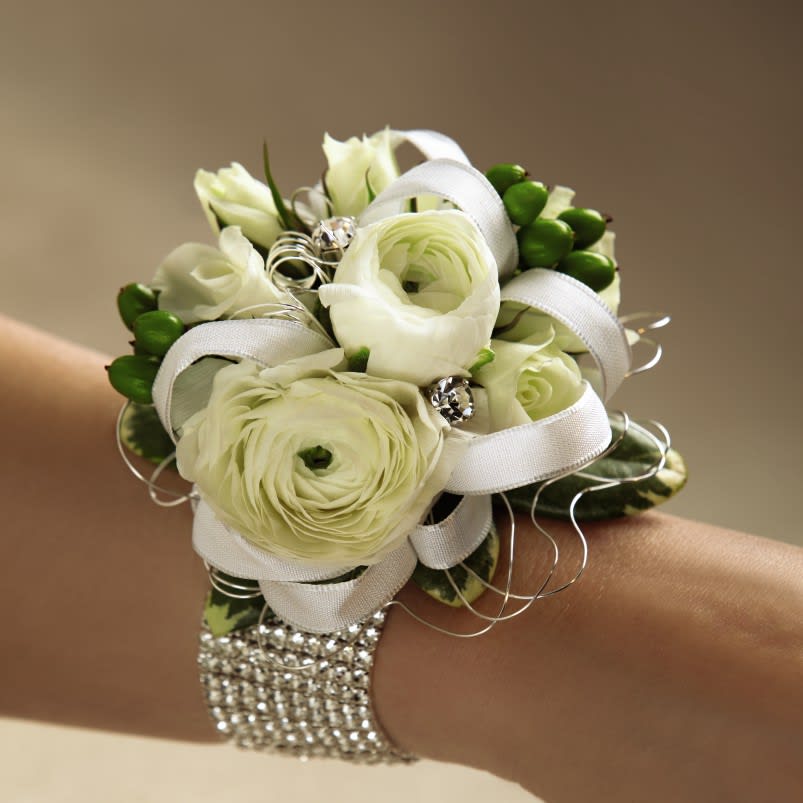 White floral wrist corsage with ribbon and rhinestone accents
