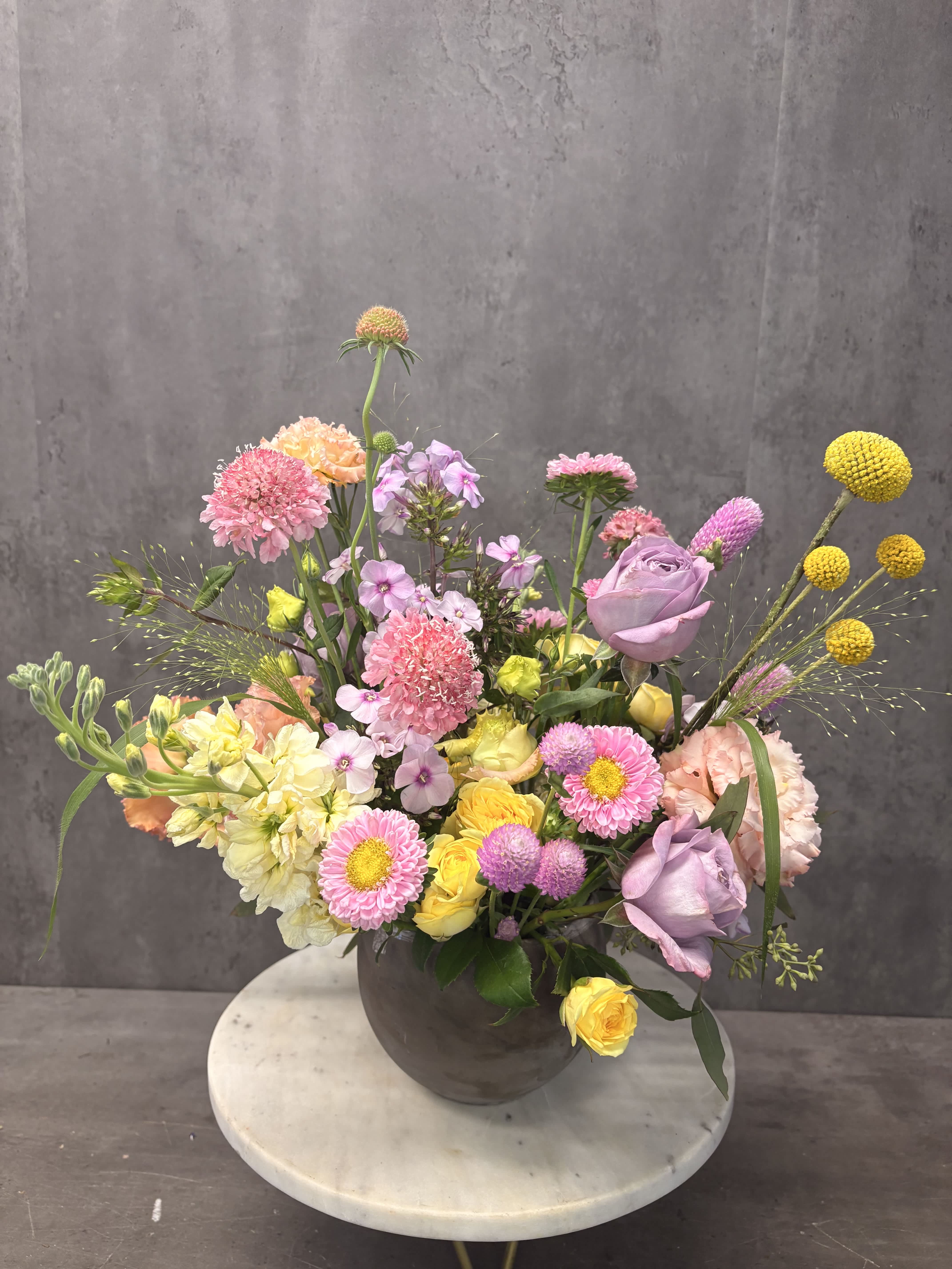 Mixed pastel flower arrangement in a dark vase