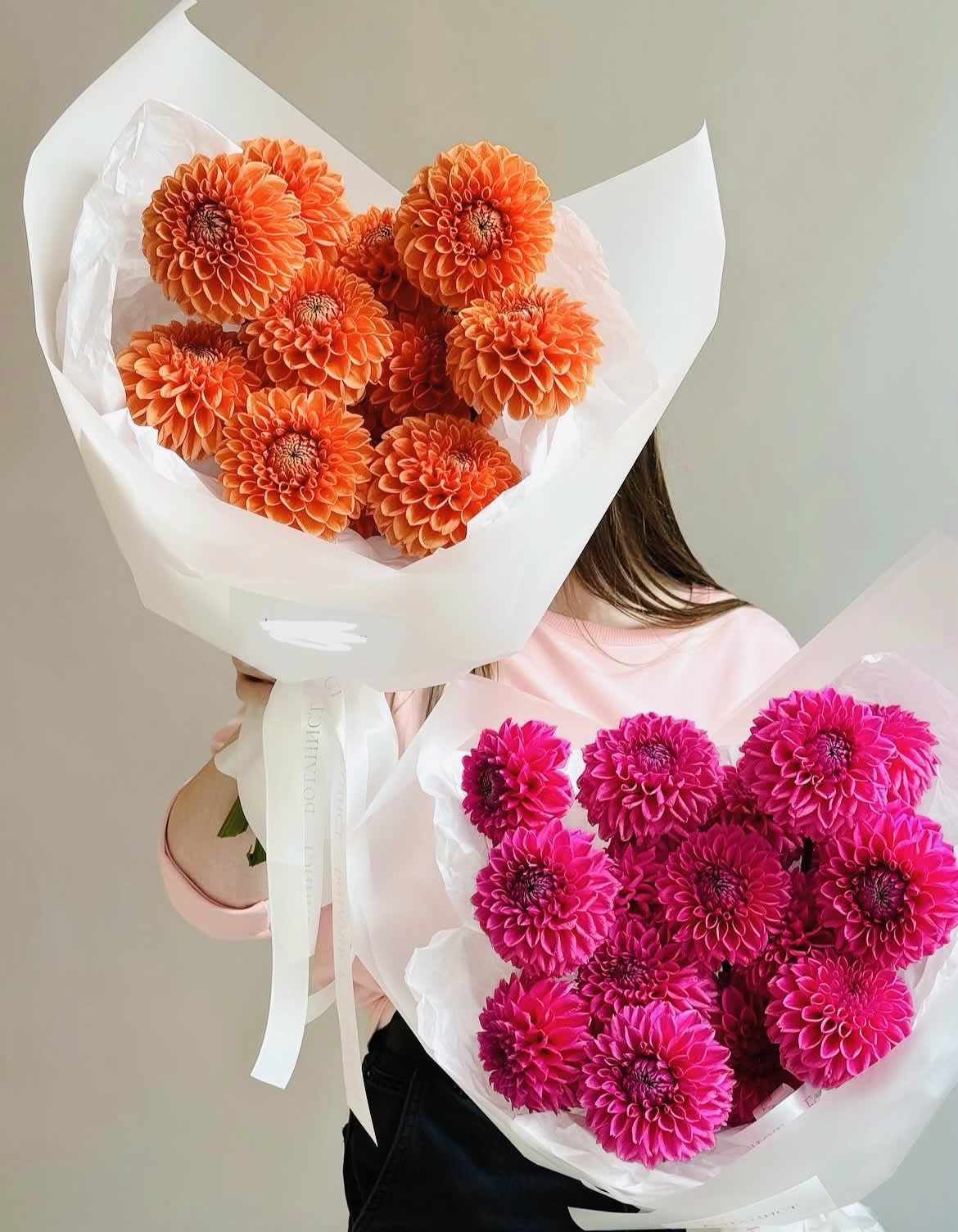Two bouquets of bright dahlias wrapped in white paper