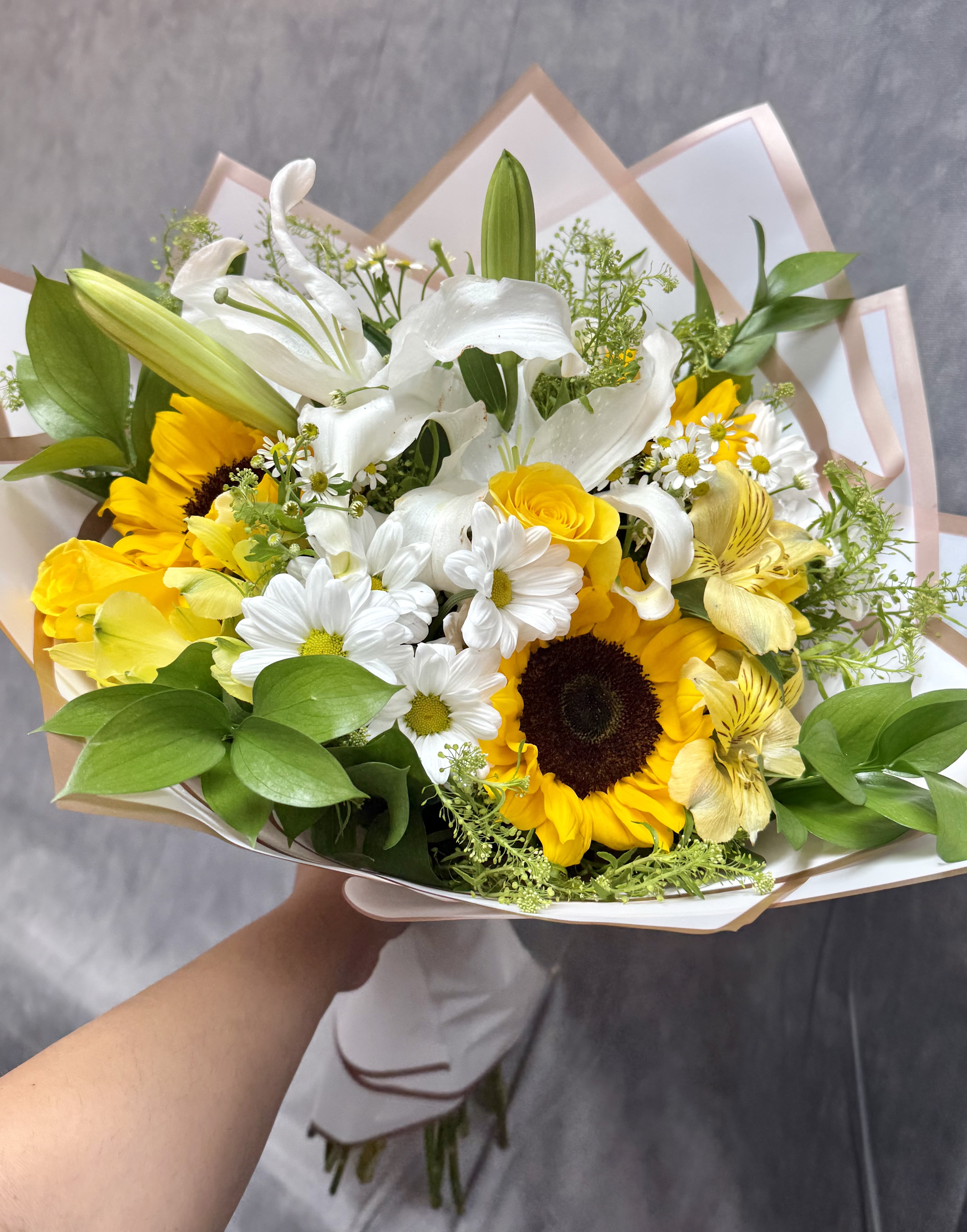 Bouquet of white lilies, sunflowers, and daisies with yellow blooms