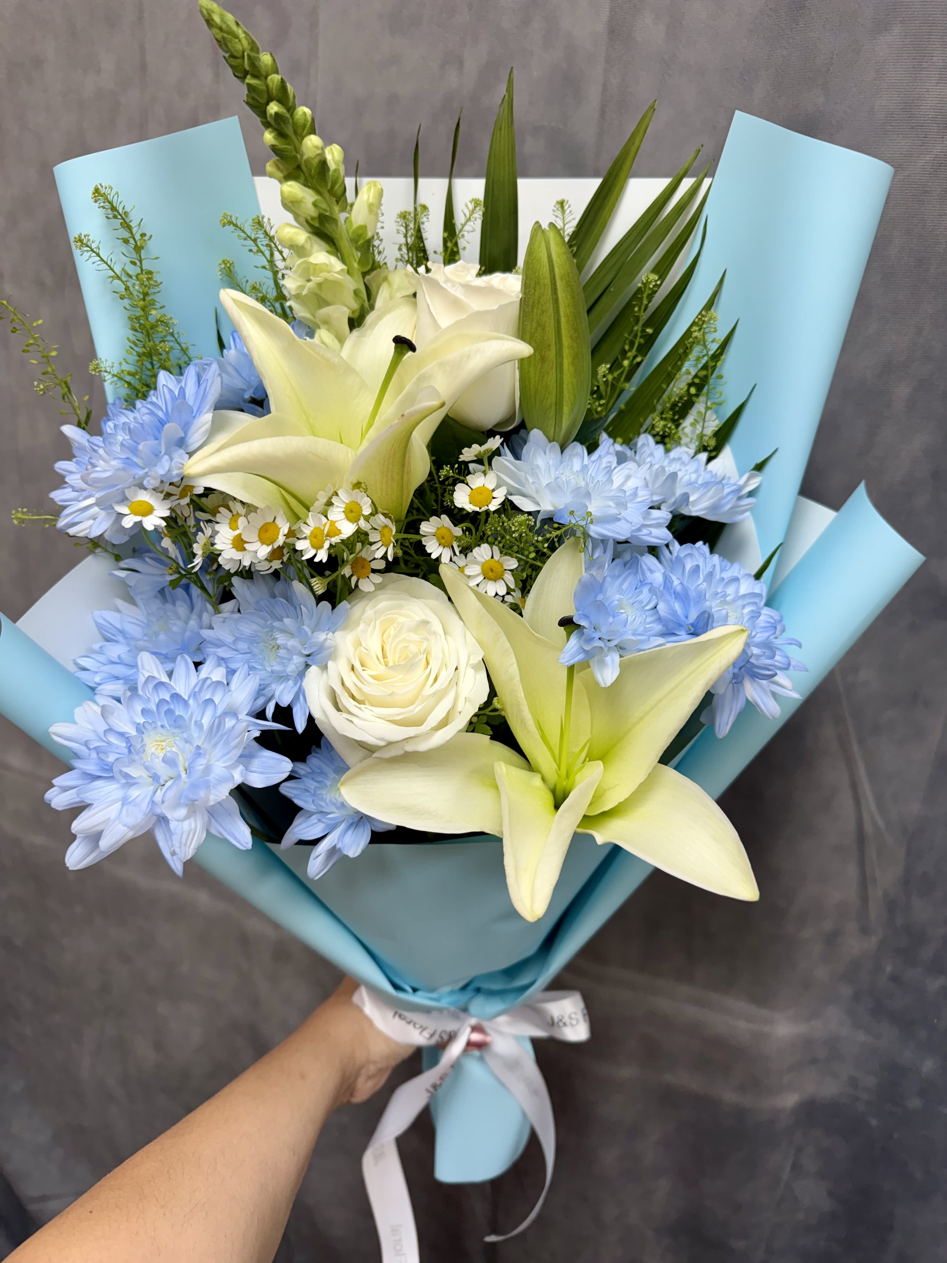 Sweet Baby Boy -  Introducing Our Sweet Baby Boy Bouquet  A soft and charming hand-tied arrangement featuring delicate white and blue blooms—perfect for welcoming a precious little one into the world. Thoughtfully designed to celebrate new beginnings with grace and joy.
