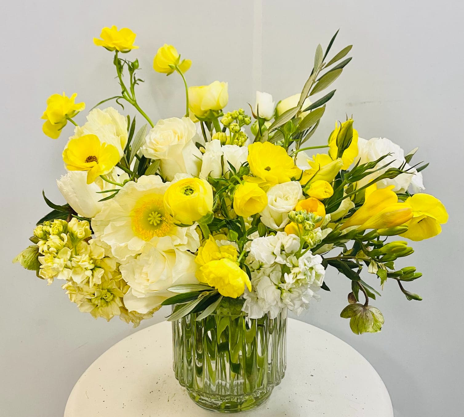 Yellow and white mixed bouquet in a clear glass vase