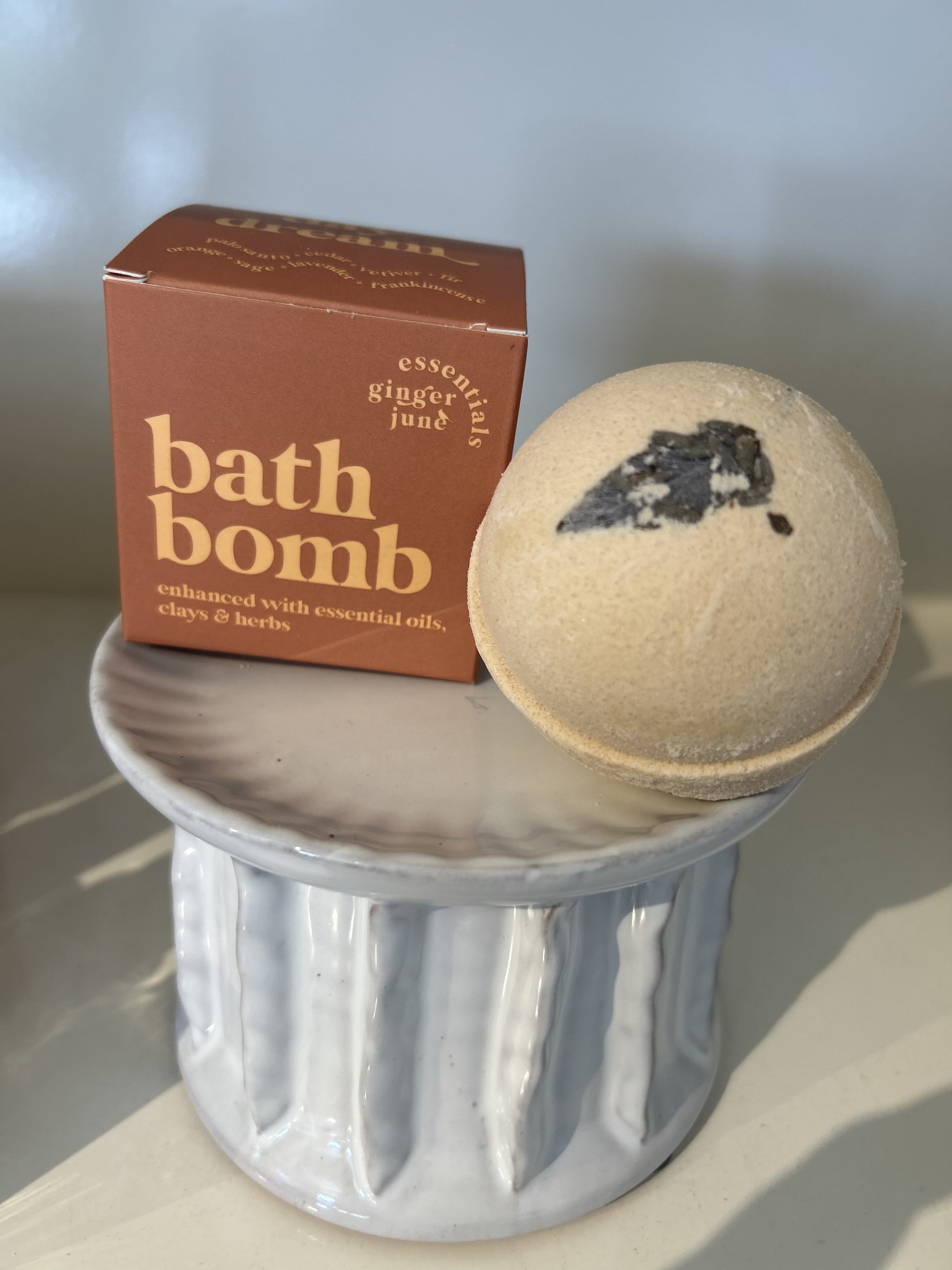 Bath bomb and boxed bath product on a small ceramic pedestal