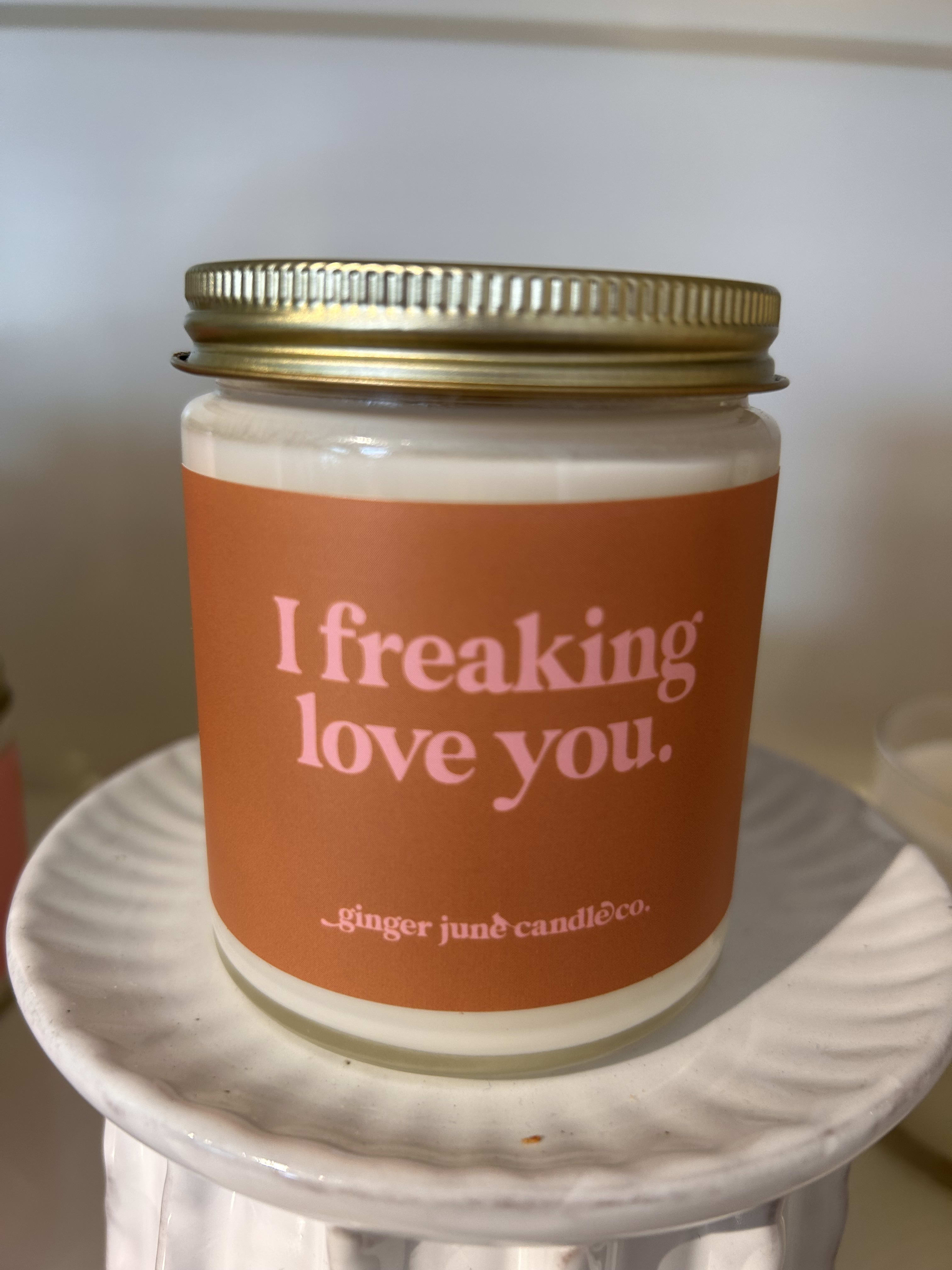 Orange-labeled candle in a glass jar with a gold lid