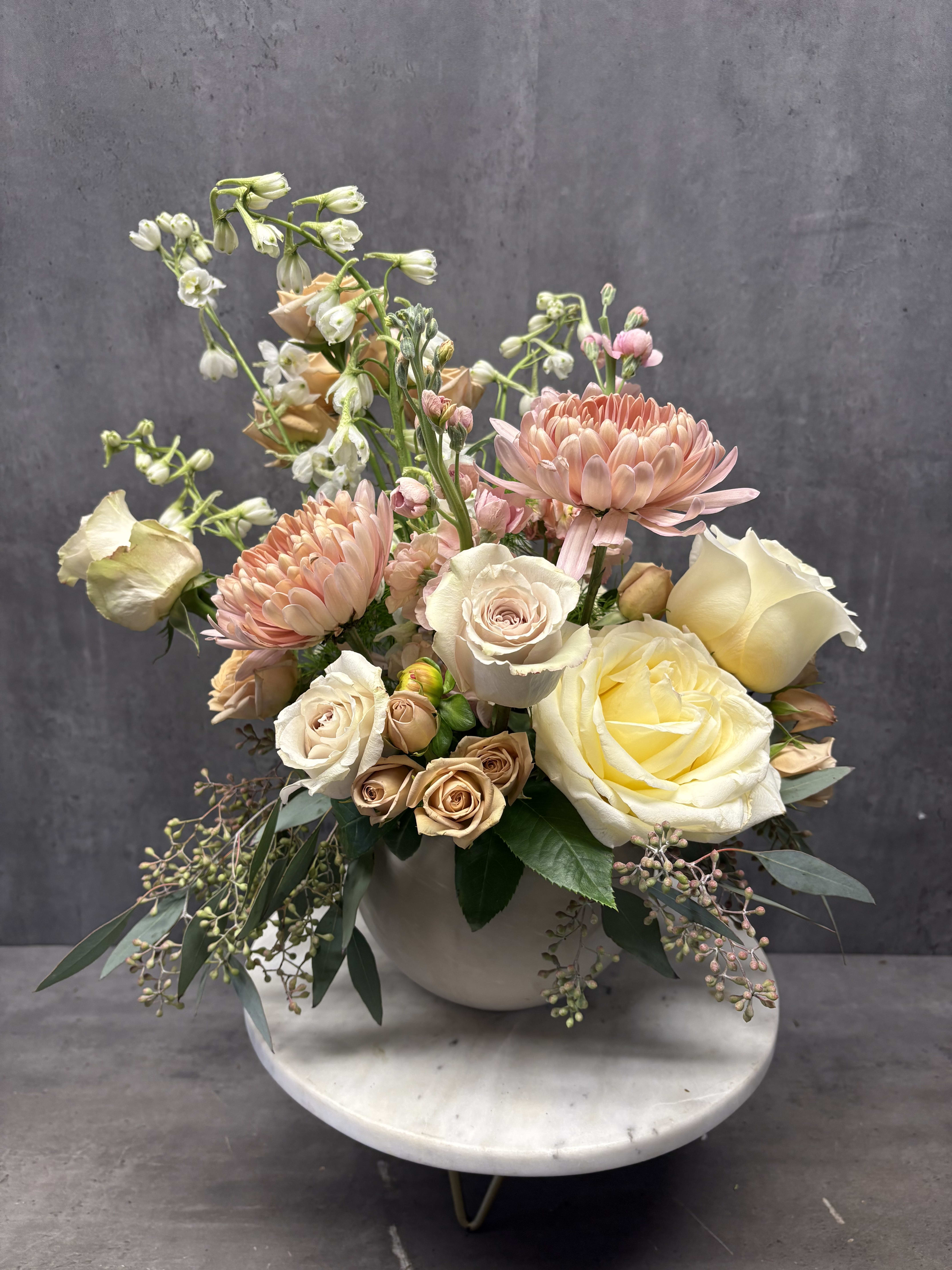 Pastel bouquet of roses and chrysanthemums in a white vase