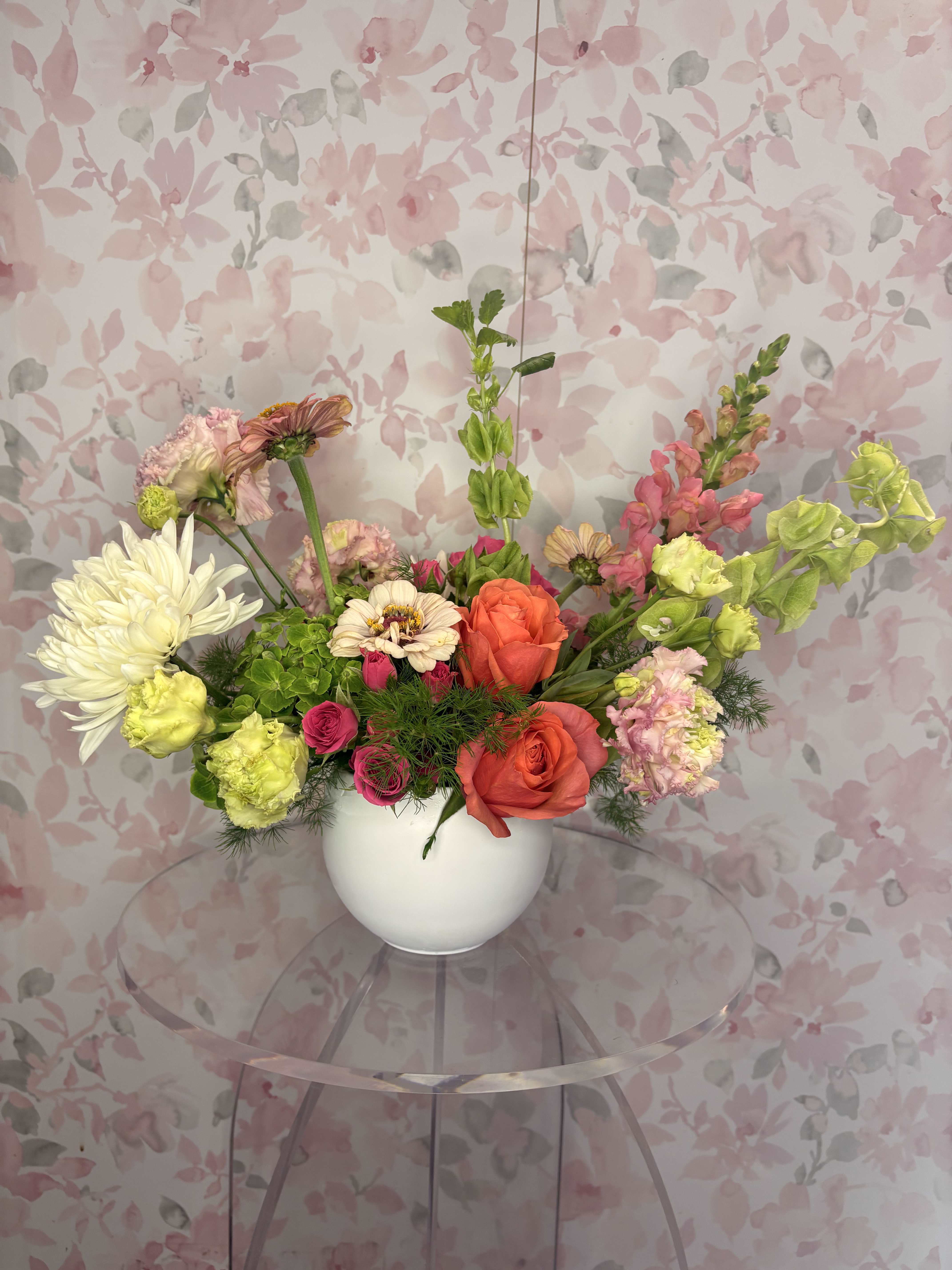 Mixed bouquet in a white vase with pink, orange, and white blooms