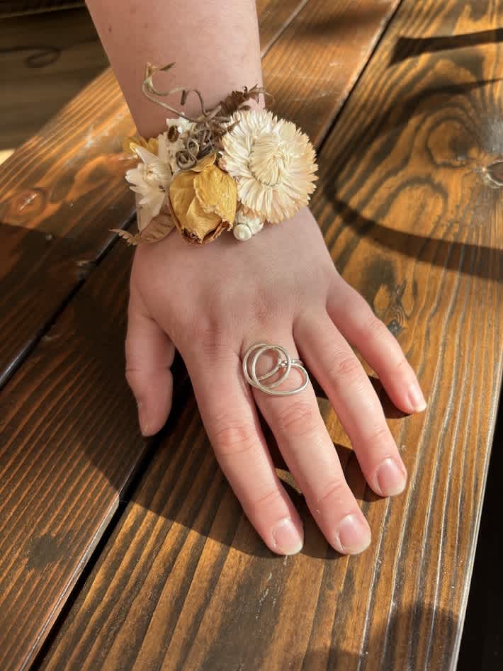 Dried flower wrist corsage on a hand
