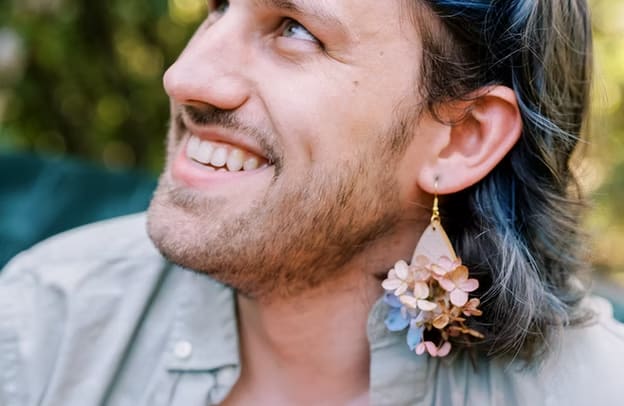 Person wearing a floral earring with small pastel blossoms