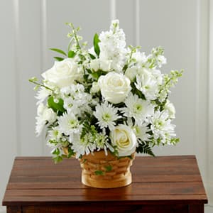 White roses and daisies arranged in a woven basket