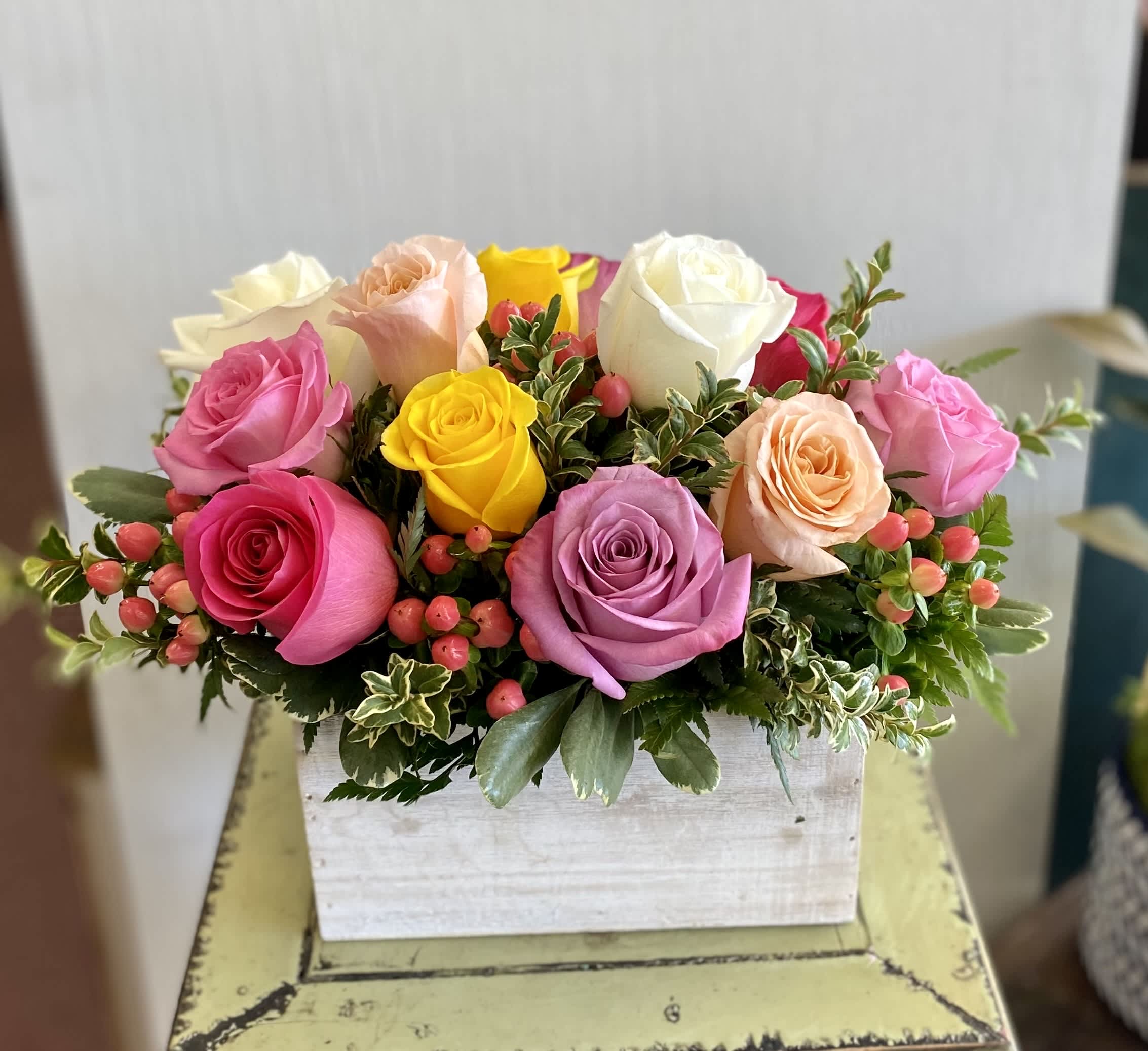 Colorful rose arrangement in a white wooden box