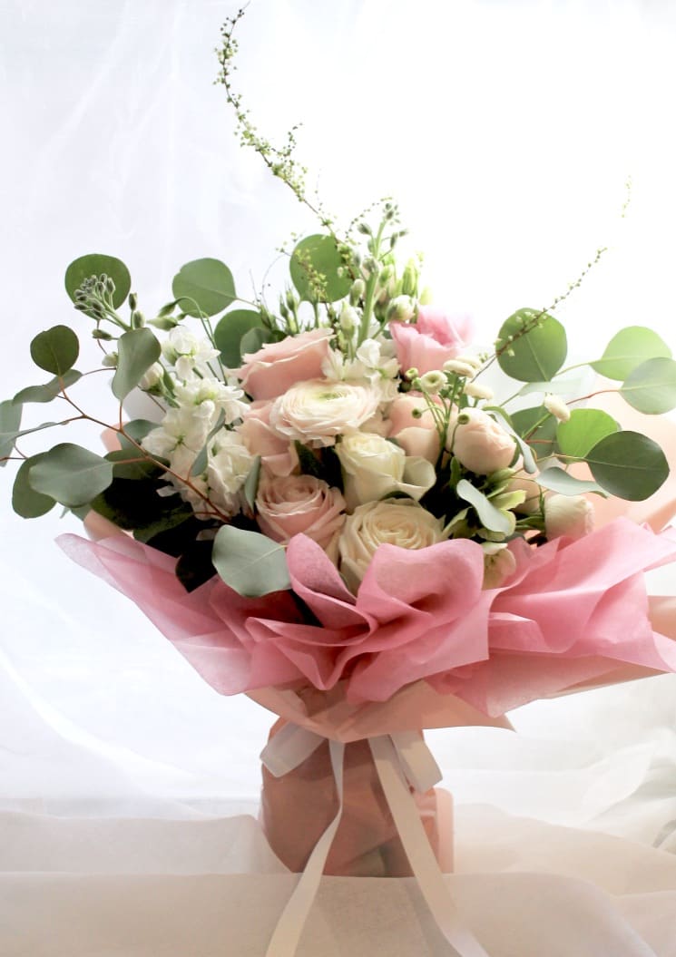 Pink and white rose bouquet with eucalyptus wrapped in pink paper