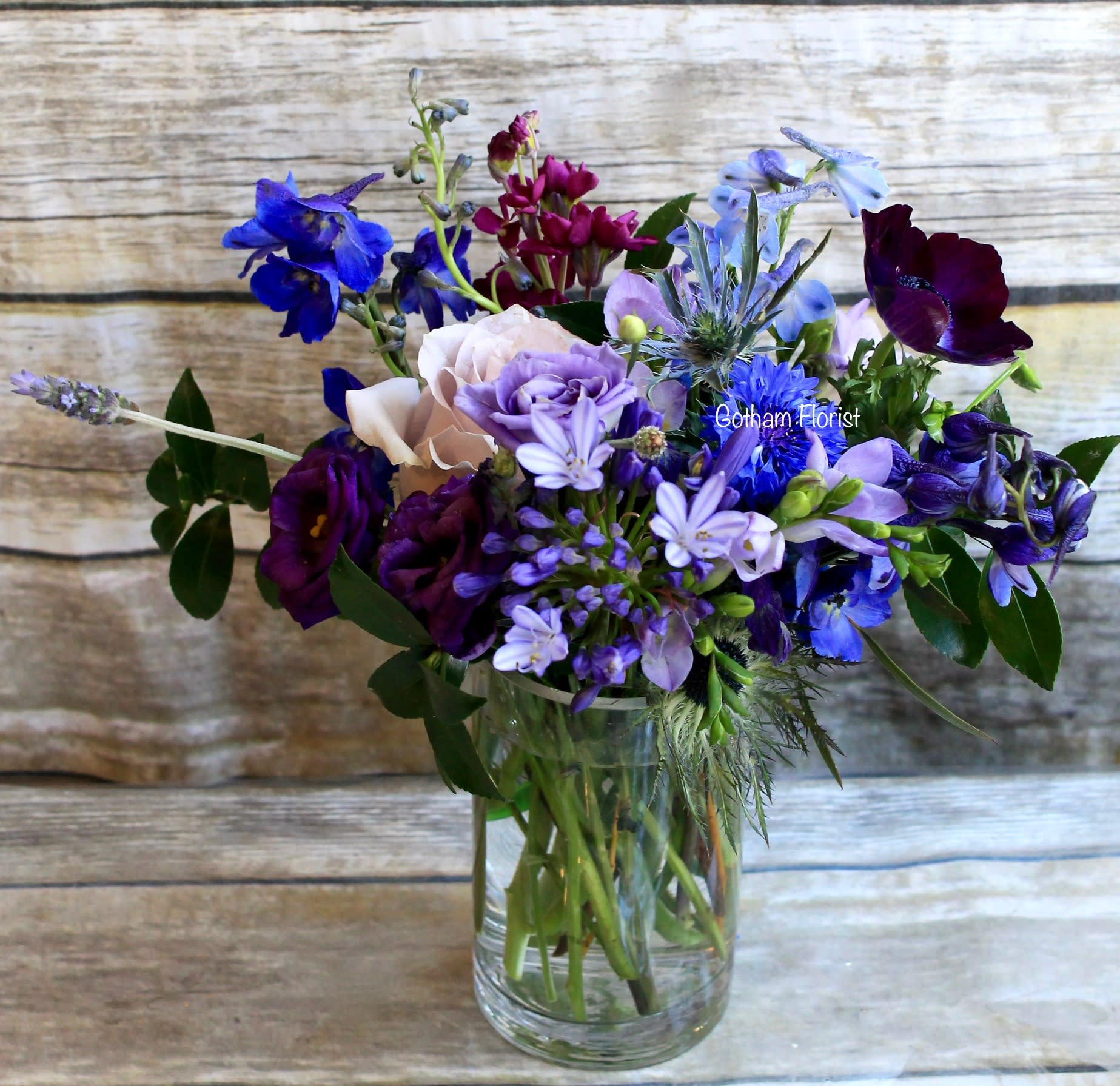 Mixed purple and blue bouquet in a clear glass vase