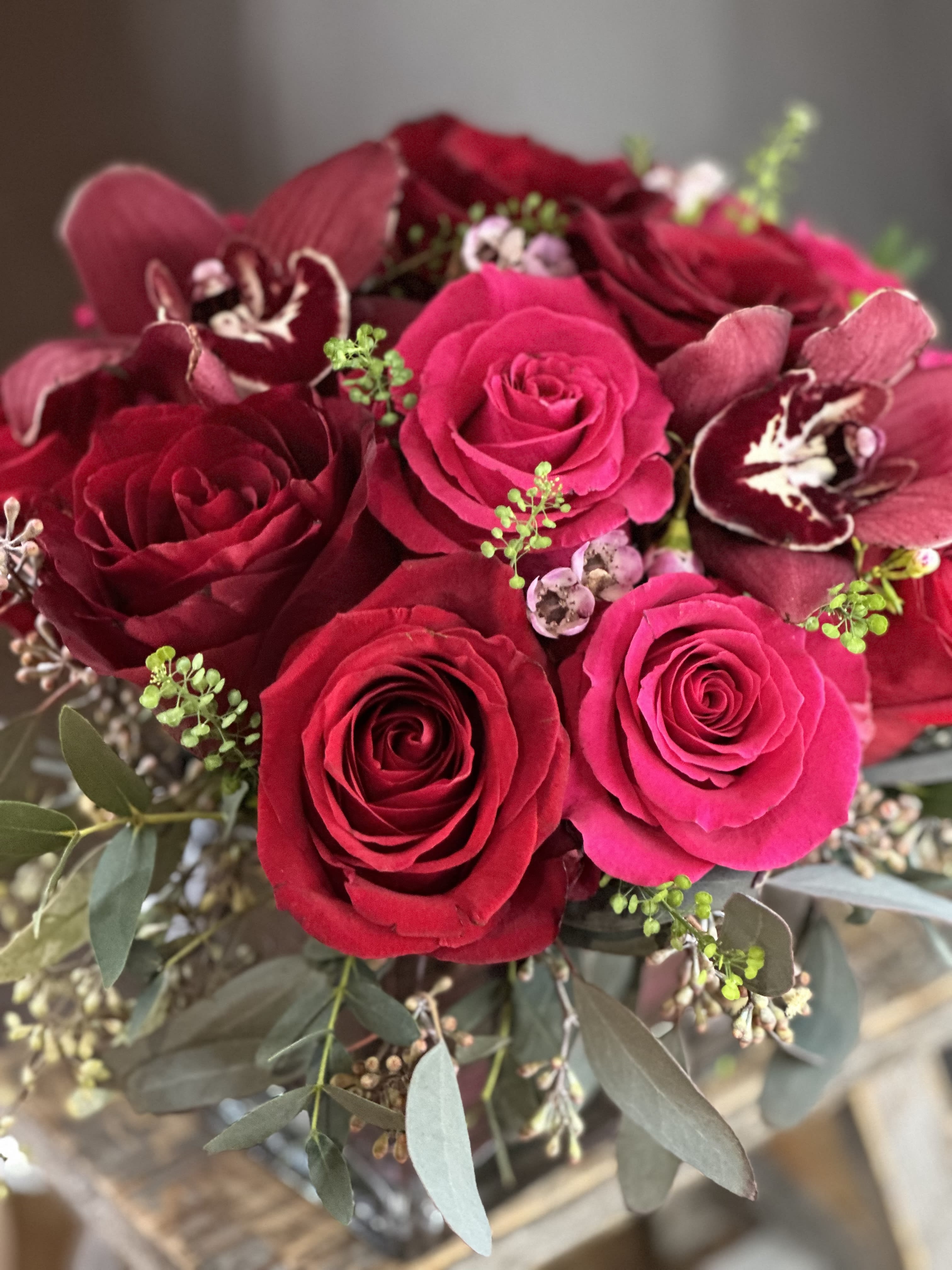 Bouquet of red roses and burgundy orchids with eucalyptus