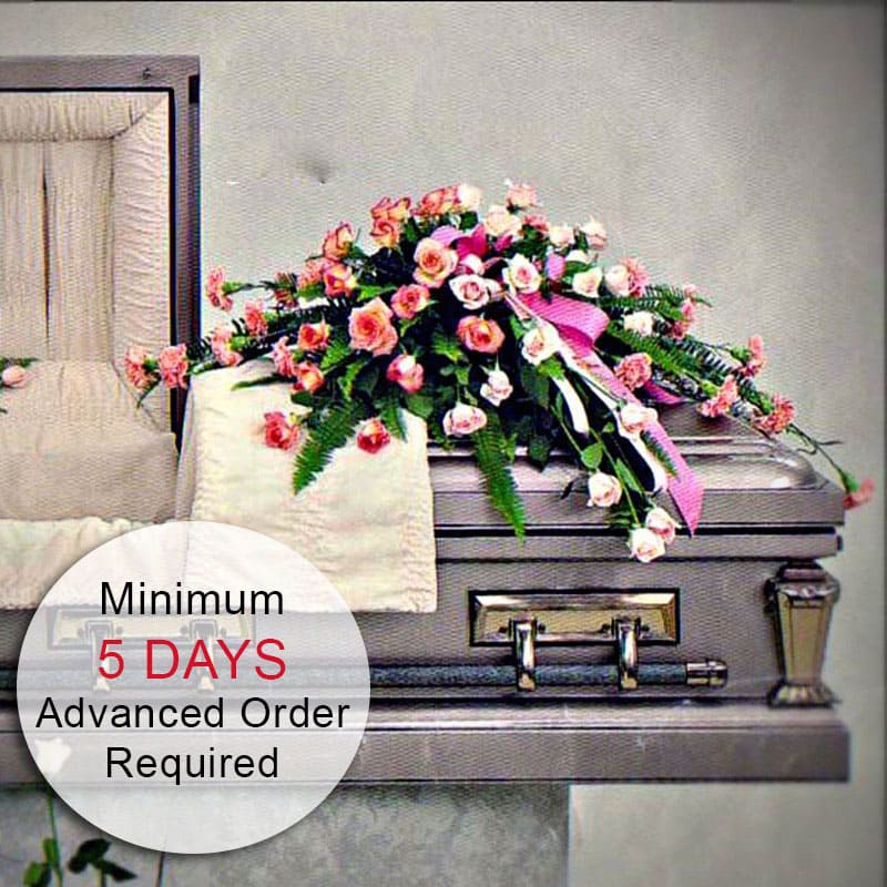 Cherished Farewell (Open Casket, Medium) - This elegant open casket spray features beautiful pink roses with a lush green base and ribbons, offering a heartfelt tribute to a loved one. Measuring approximately 36" wide, this arrangement provides a stunning and meaningful display. Due to the intricate design work, a minimum of 5 days' advance notice is required to ensure that the flowers can be properly staged for quality results. The piece is created as a one-sided arrangement for maximum visual value.  Key Features:  Stunning Dimensions: Measures approximately 36" wide, creating an impressive and elegant display.  High-Quality Arrangement: Expertly crafted with fresh pink roses, a green base, and elegant ribbons to ensure lasting beauty and impact.  One-Sided Design: Created as a one-sided piece for maximum visual value and elegance. Elegant Presentation: Perfect for memorials, celebrations of life, or any event where a stylish and beautiful tribute is desired.  Meaningful Tribute: Designed to honor and celebrate the life of a loved one with grace and elegance.  Advanced Notice Required: A minimum of 5 days' notice is needed to ensure the flowers can be staged for the best quality results.  Celebrate and honor the memory of a loved one with our Pink Rose Closed Casket Spray, a beautiful and meaningful tribute that reflects love and remembrance.  