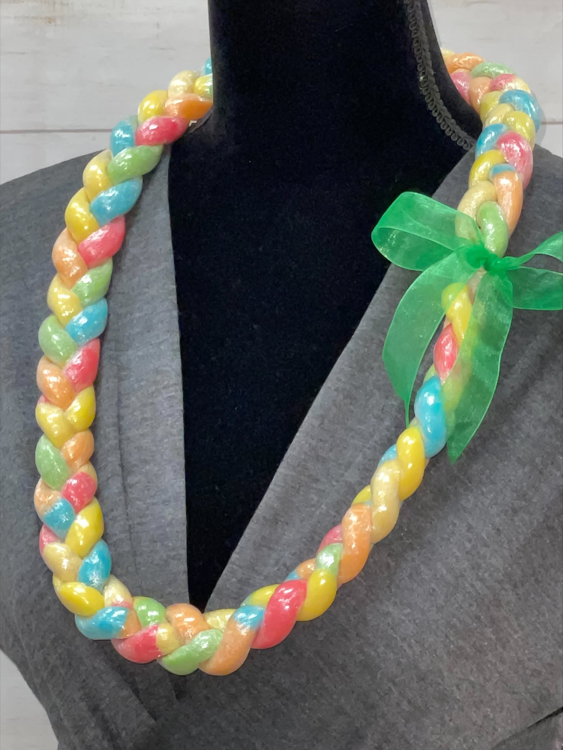 Braided multi-color candy lei with green ribbon bow displayed on a black mannequin