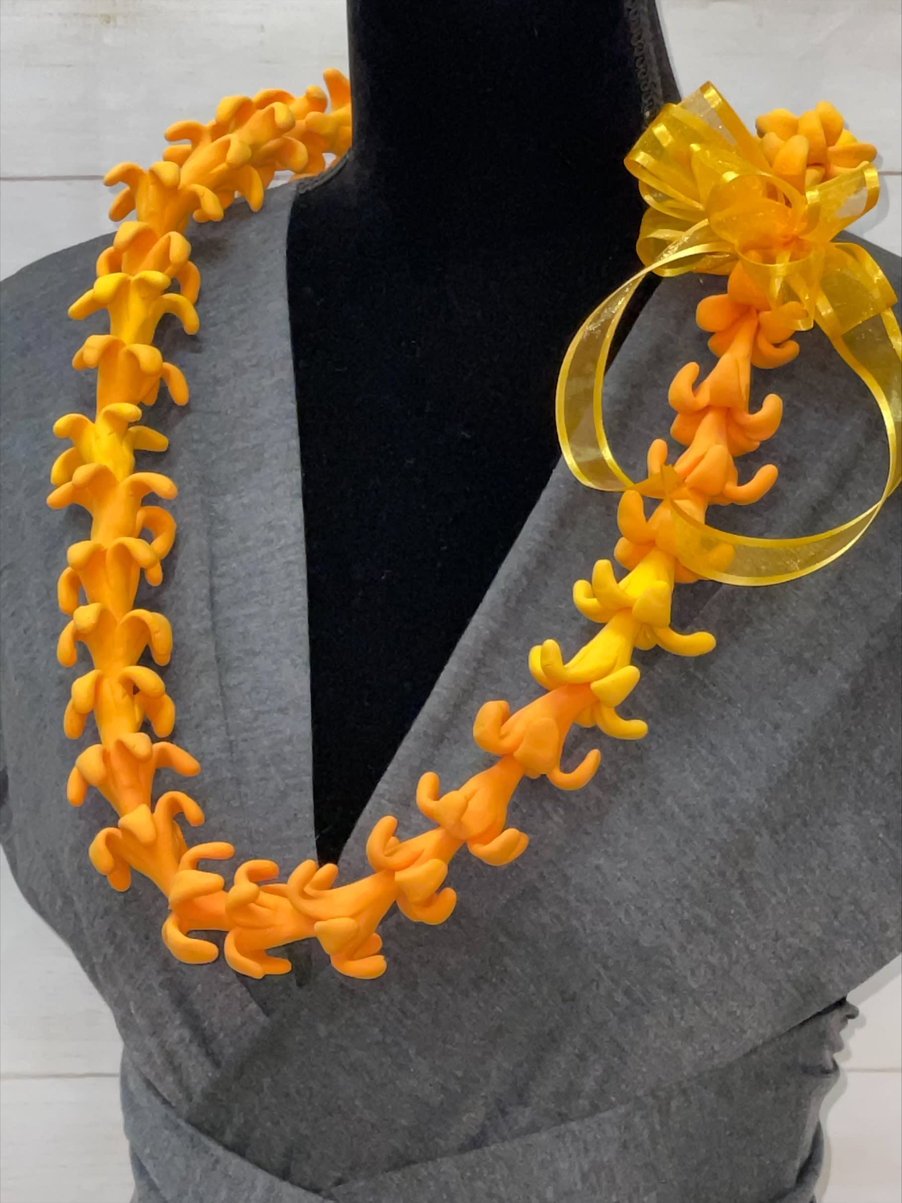 Bright orange artificial flower lei with a yellow ribbon bow on a black mannequin.