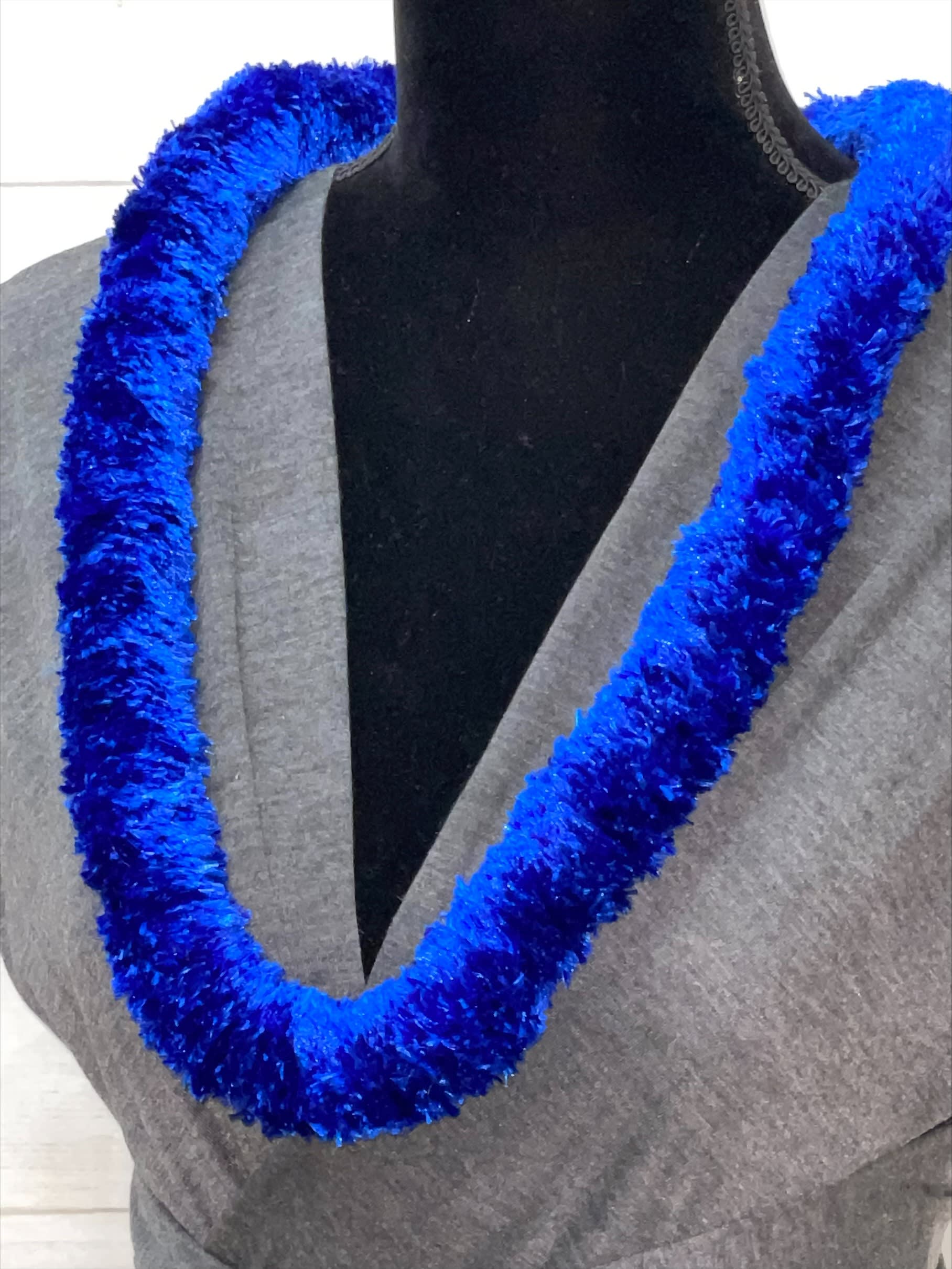 Bright blue fluffy lei necklace displayed on a dress form