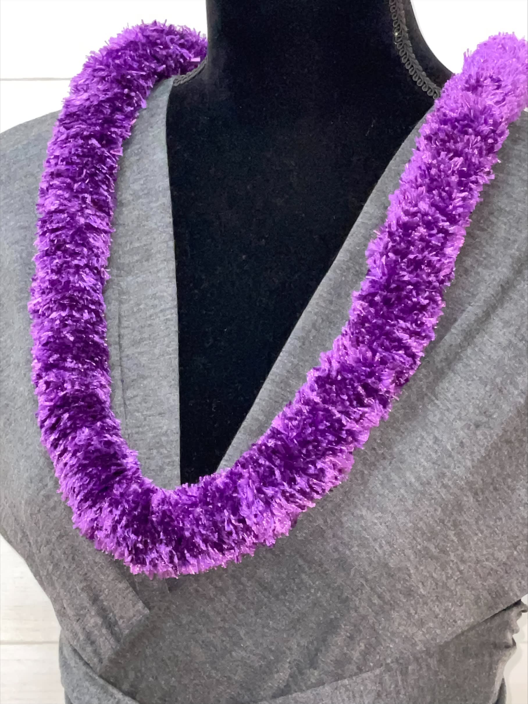Plush purple lei necklace displayed on a black mannequin torso