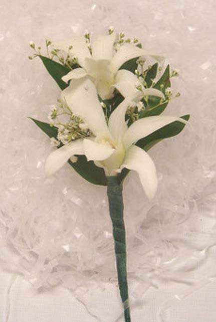 White lily boutonniere with small white filler flowers on a white background